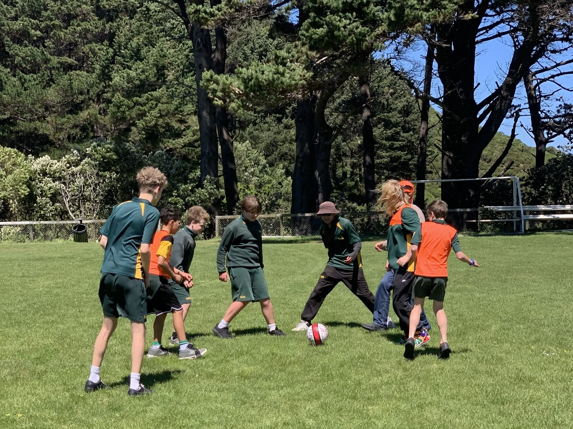 Rangatahi involved in Tuāwhana programme kick a ball around on a grass field
