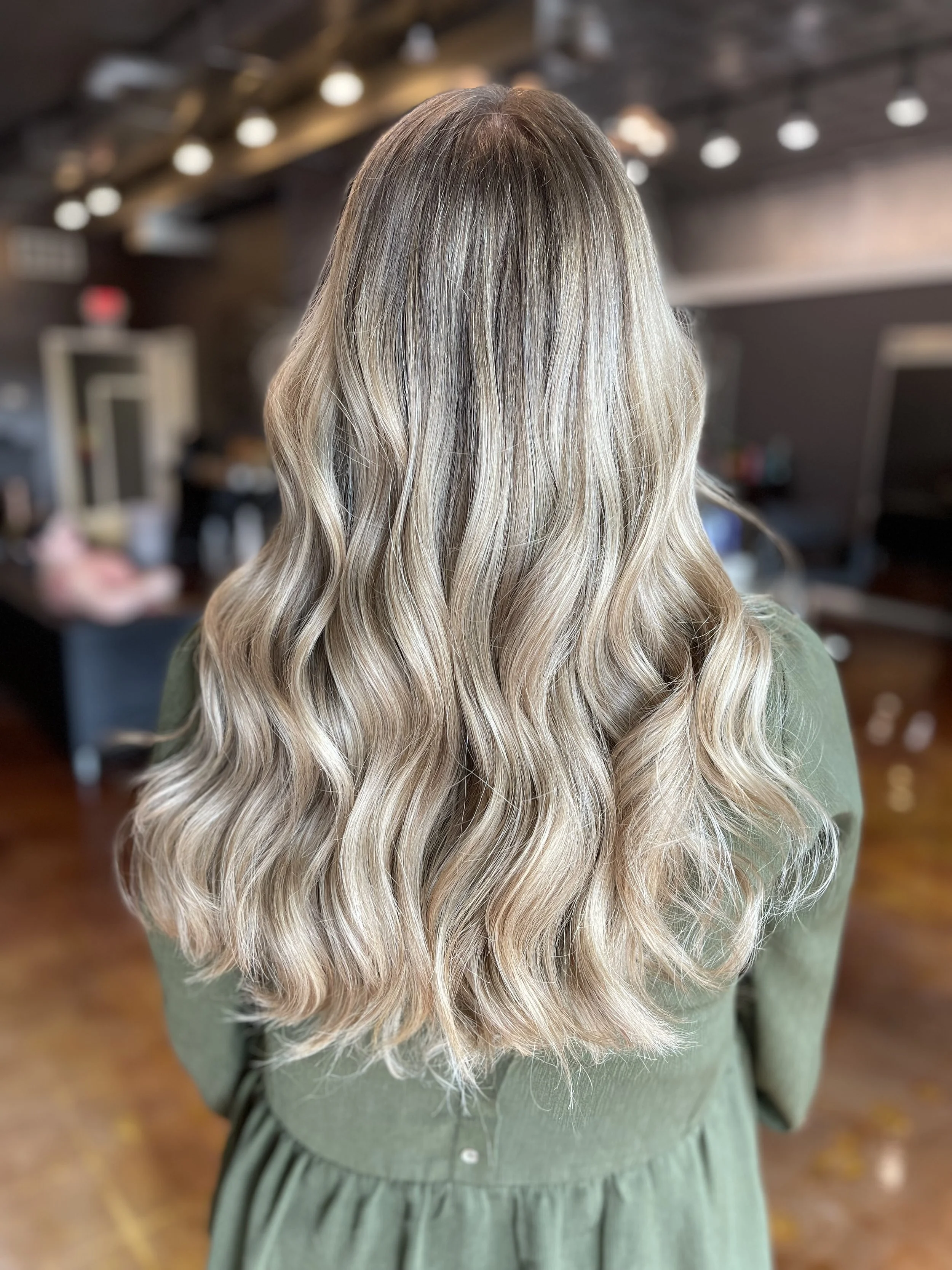 Soft blonde waves on long hair, styled with dimension and volume at The Nicole Martin Salon in St. Louis.