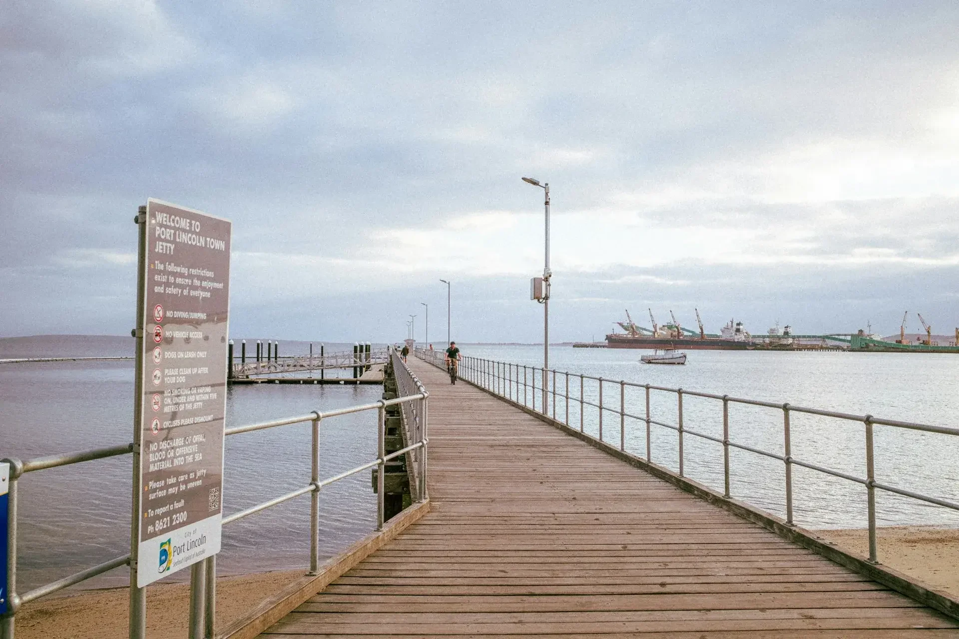 The timber Port Lincoln Town Jetty stretching out over calm water.
