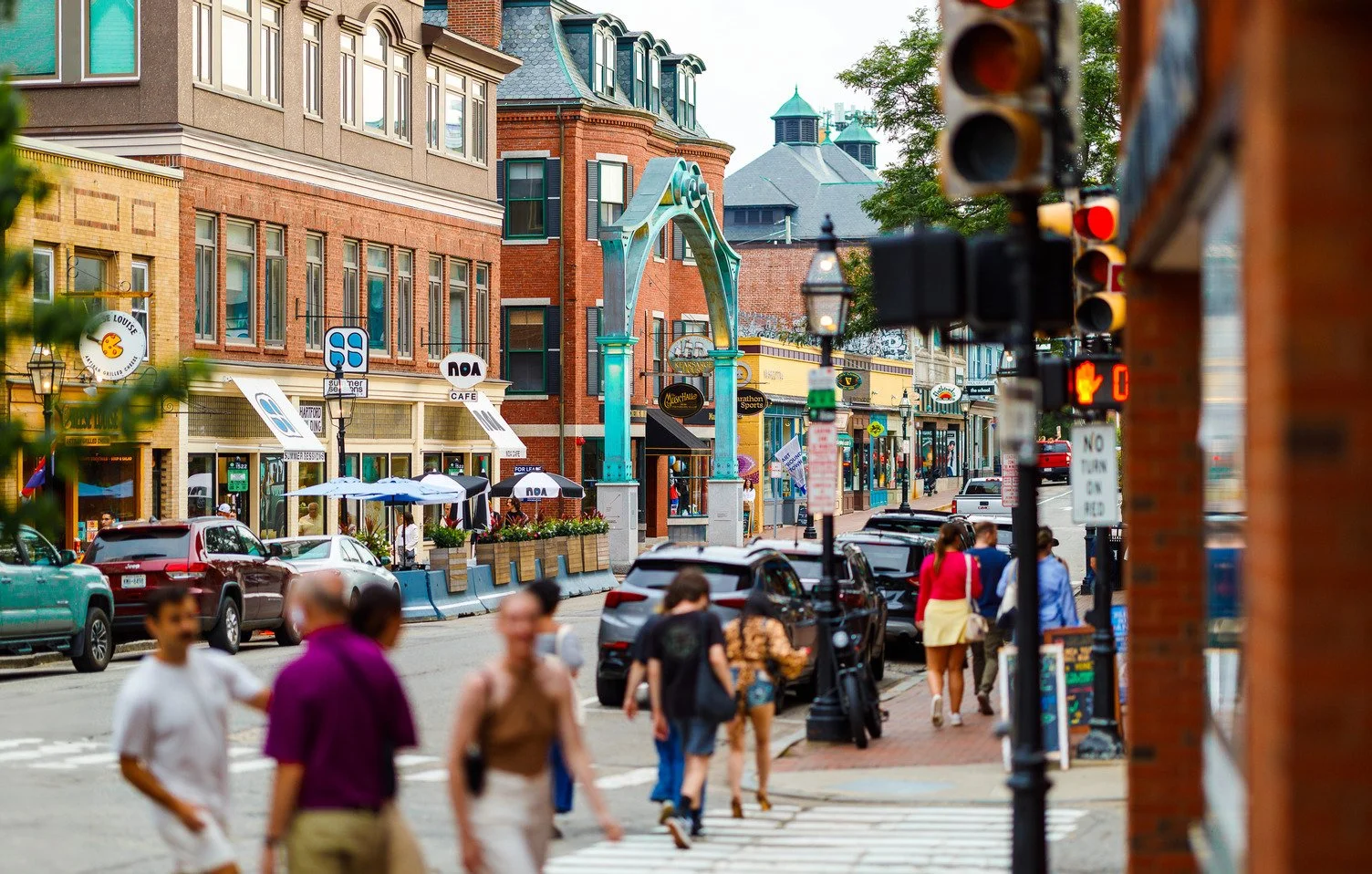 Downtown Portsmouth, NH, street scene featuring historic buildings, local shops, restaurants, and pedestrians near Market Square.