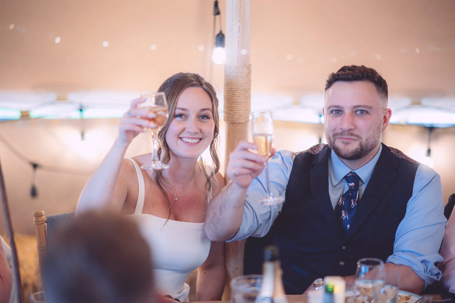 Bride and groom raising a toast during speeches at Jenners Barn