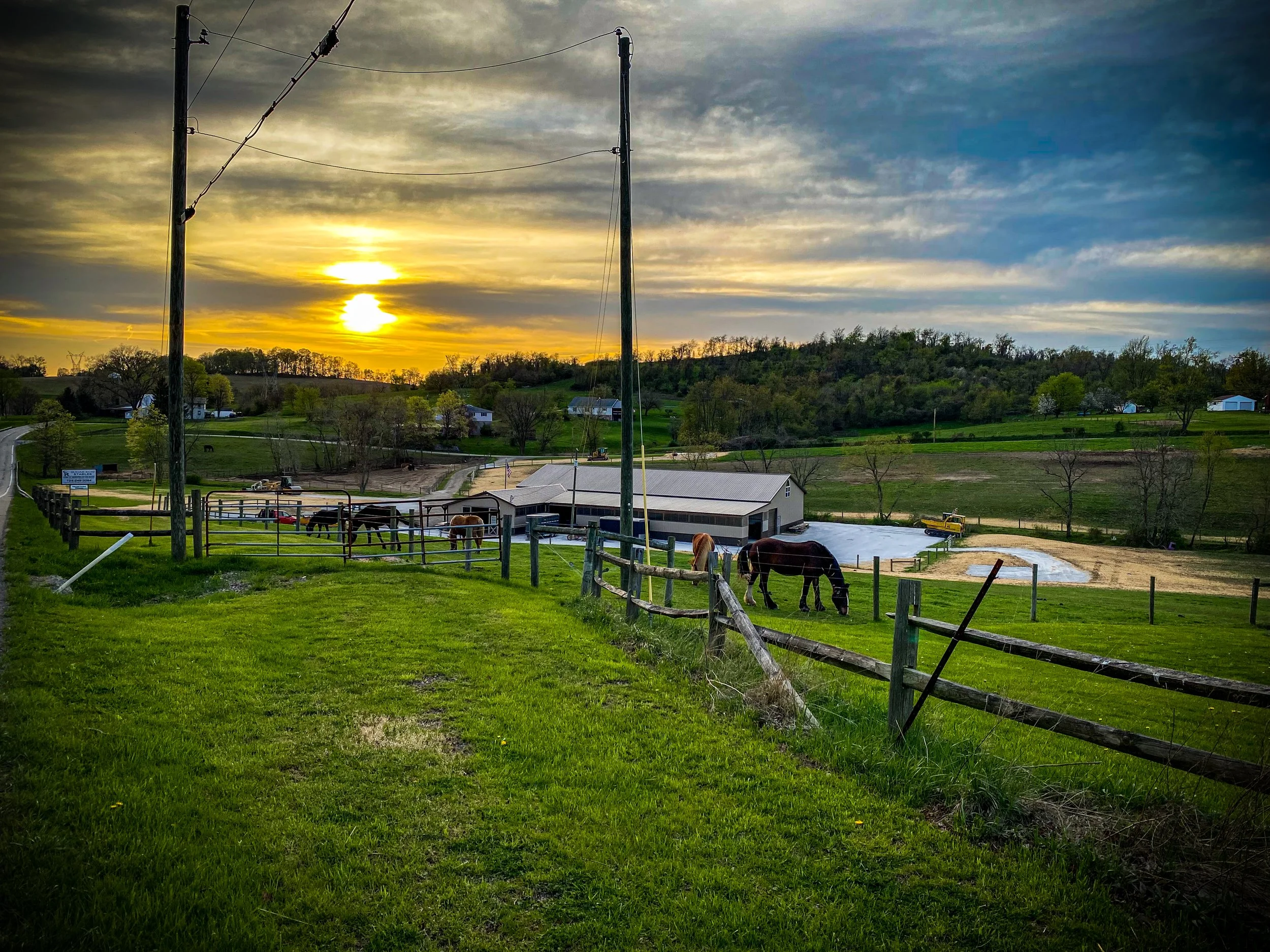 sunset over horse farm stables