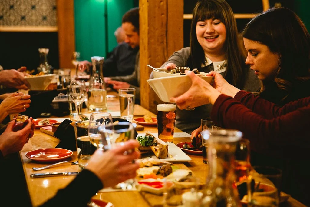 People enjoying a meal with a large group.