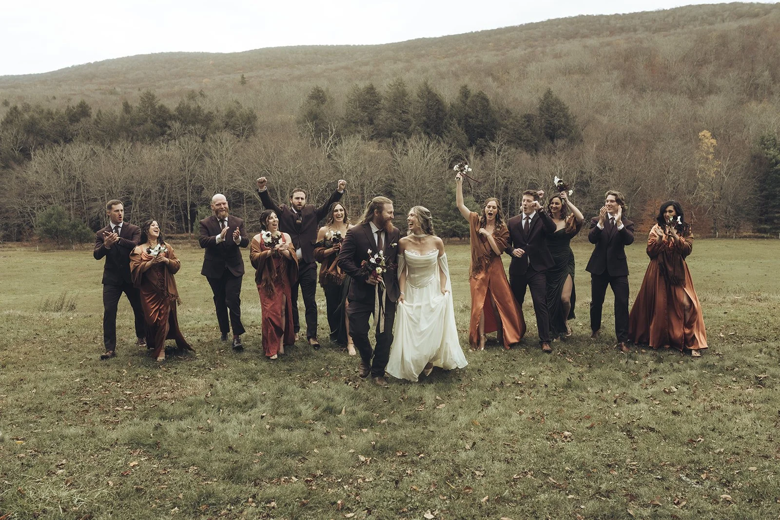 Bride and groom kissing under a clear umbrella in a wooded area.