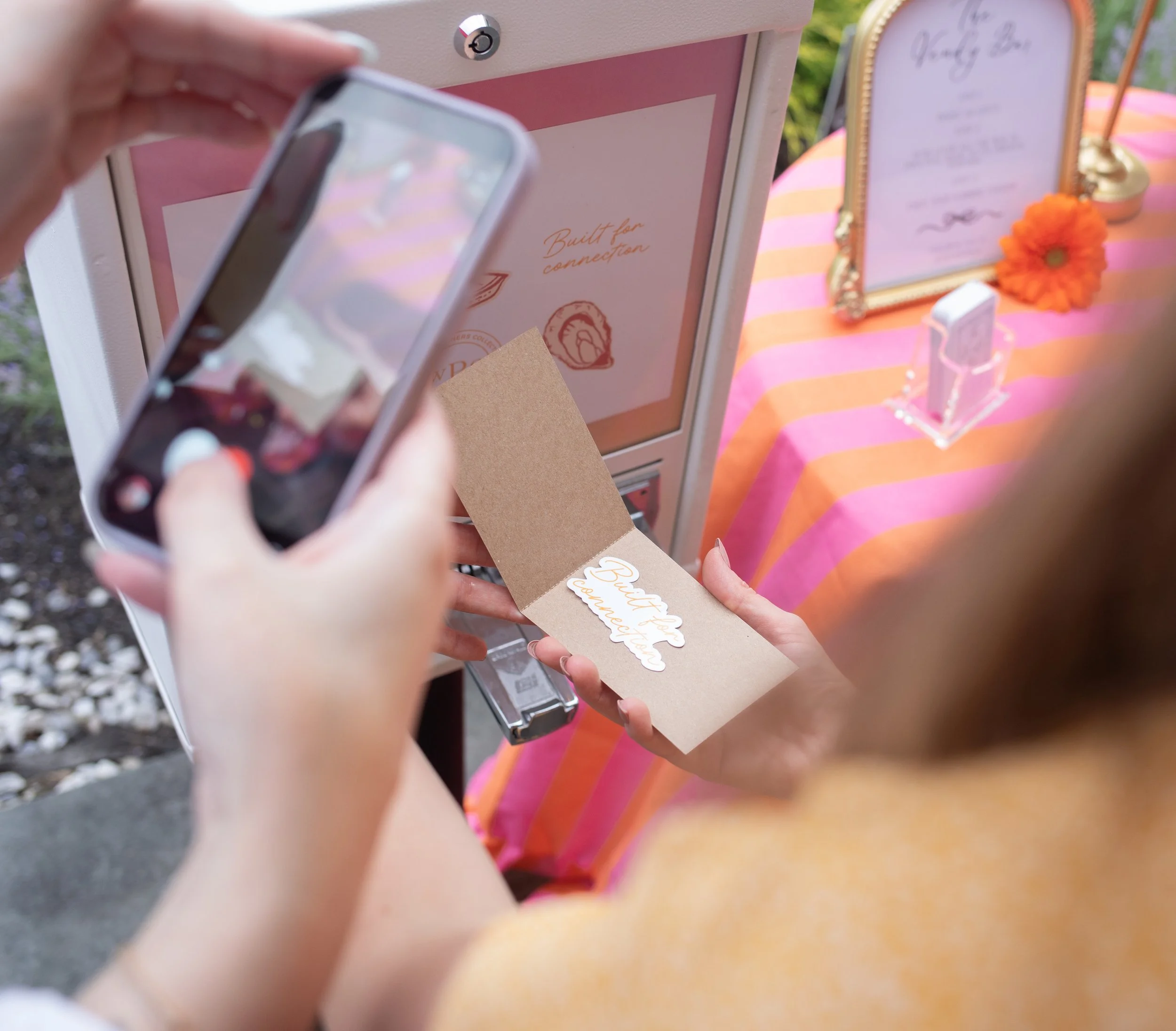 Guest using the custom sticker vending machine at The Wedding Planners Collective's Golden Hour Social in Wallkill, New York.