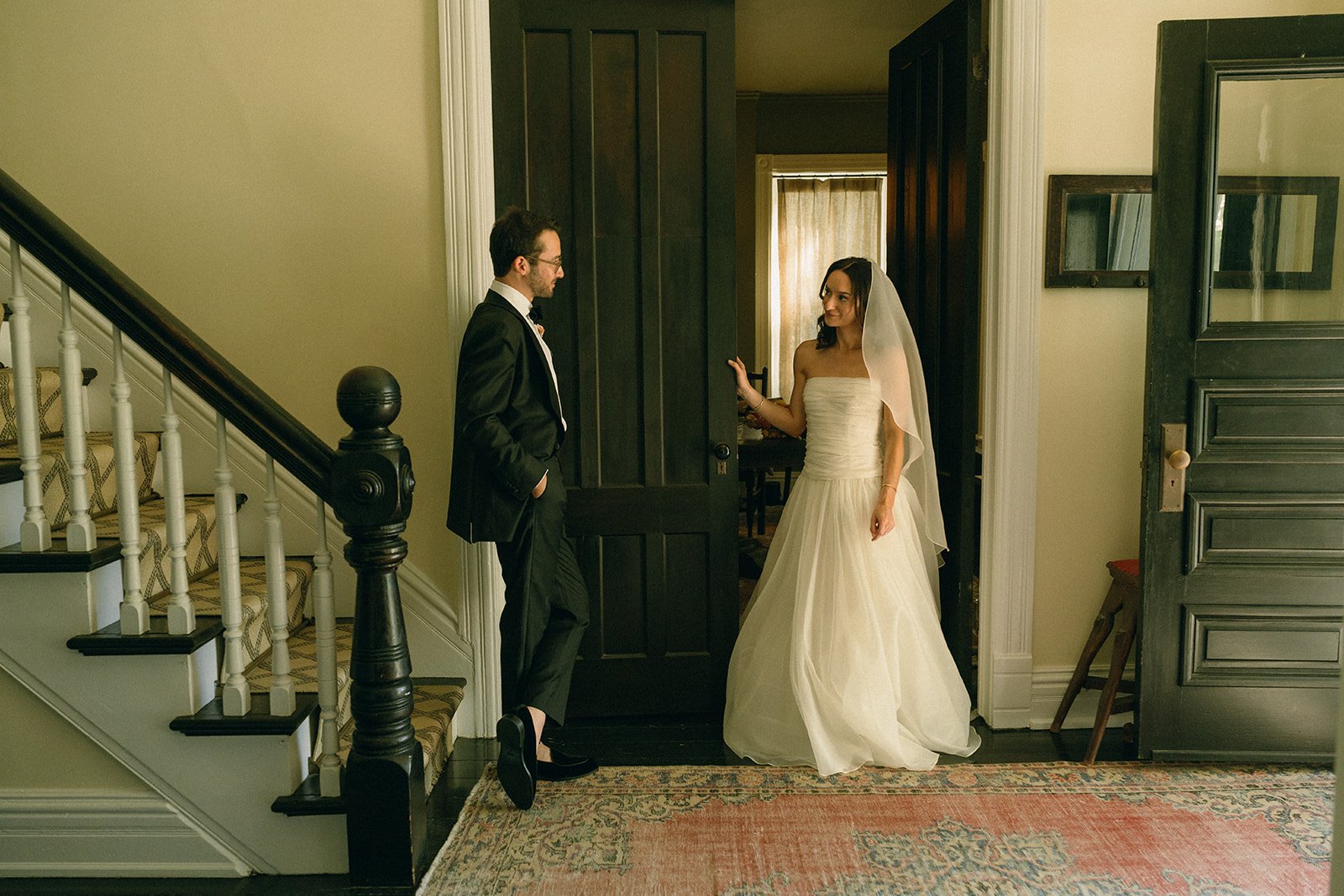 Person arranging flowers outdoors next to white chairs on grass.