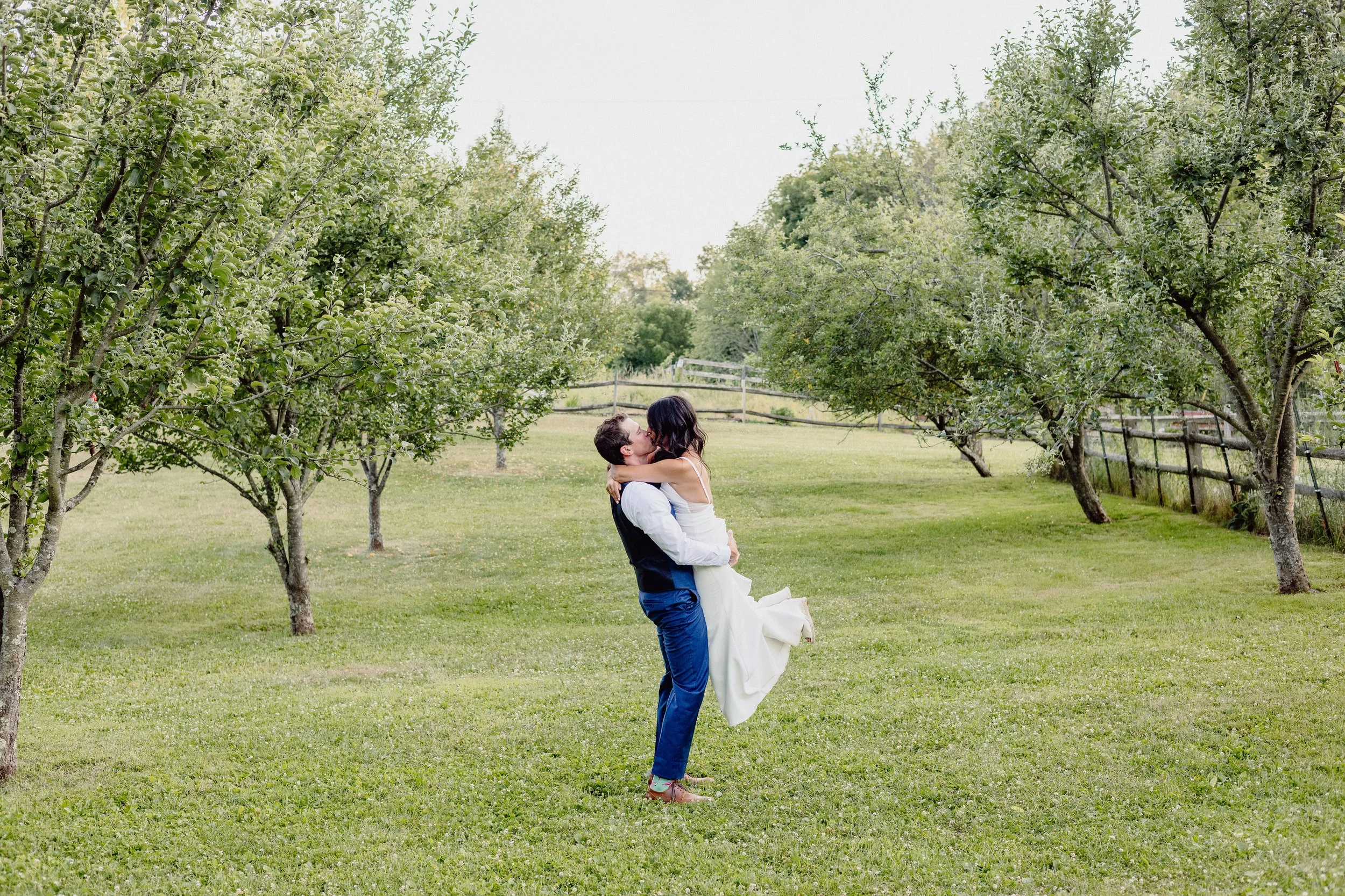 Groom lifting bride in Hudson Valley orchard wedding Service Matters North East