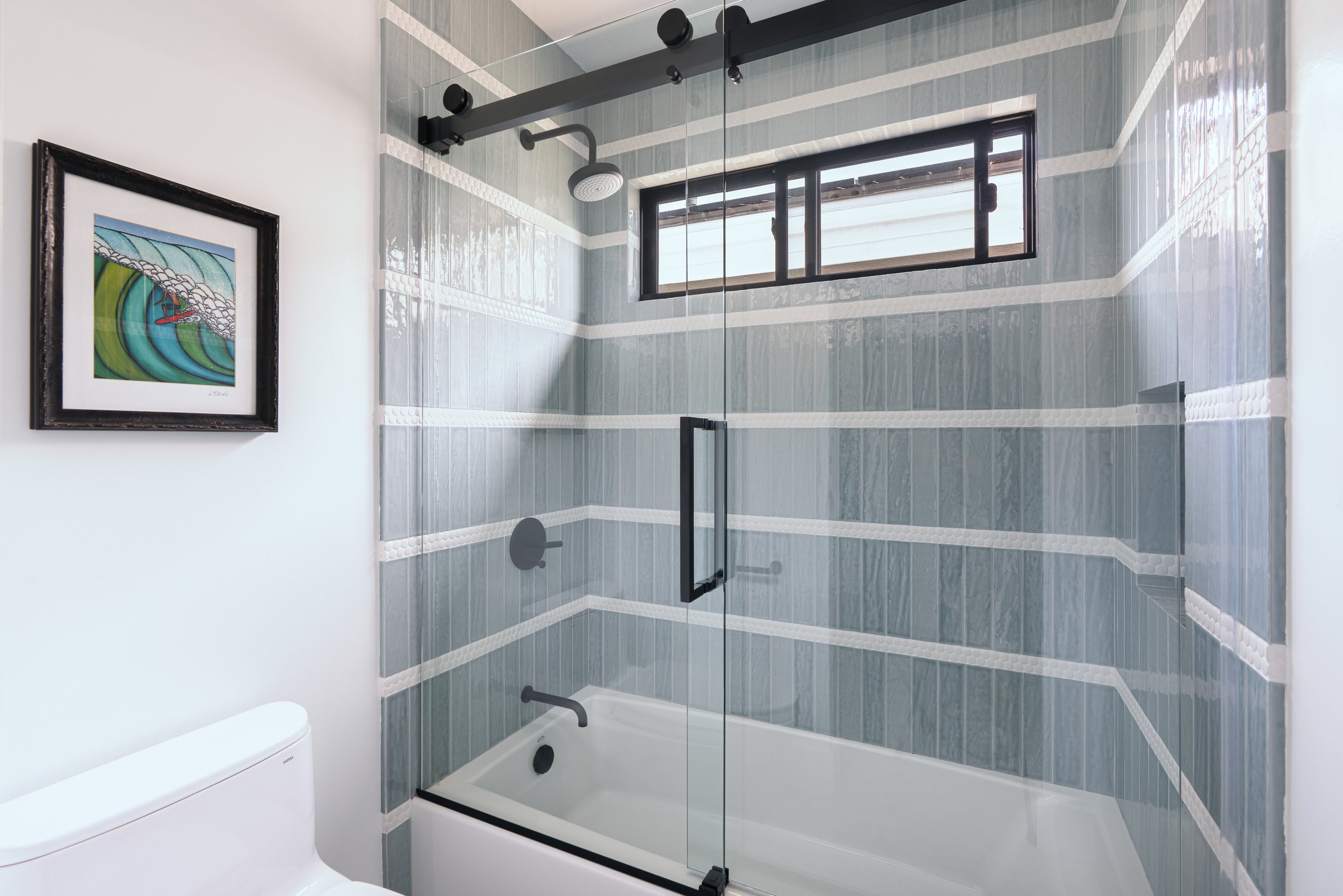 Beachy blue guest bathroom remodel with black accents in Newport Beach, CA