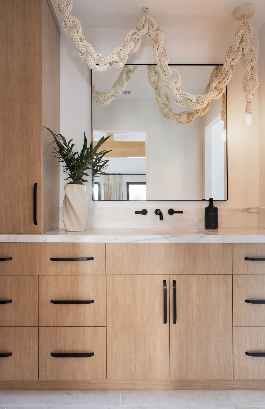 Coastal guest bathroom vanity in white oak with hanging Coco Chain Link Swag Pendant by Palecek in Newport Beach, CA