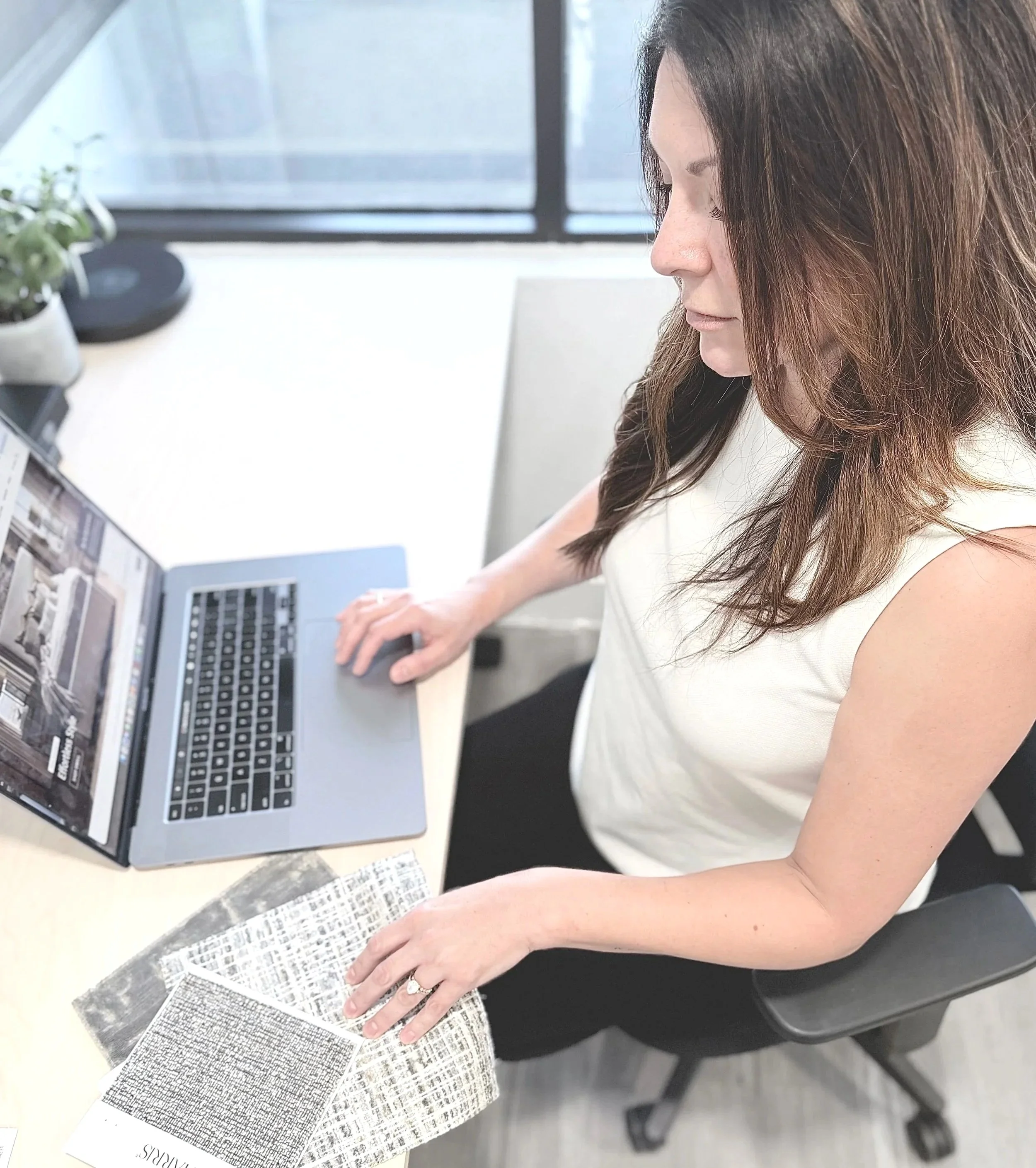 Designer at desk with computer and paper