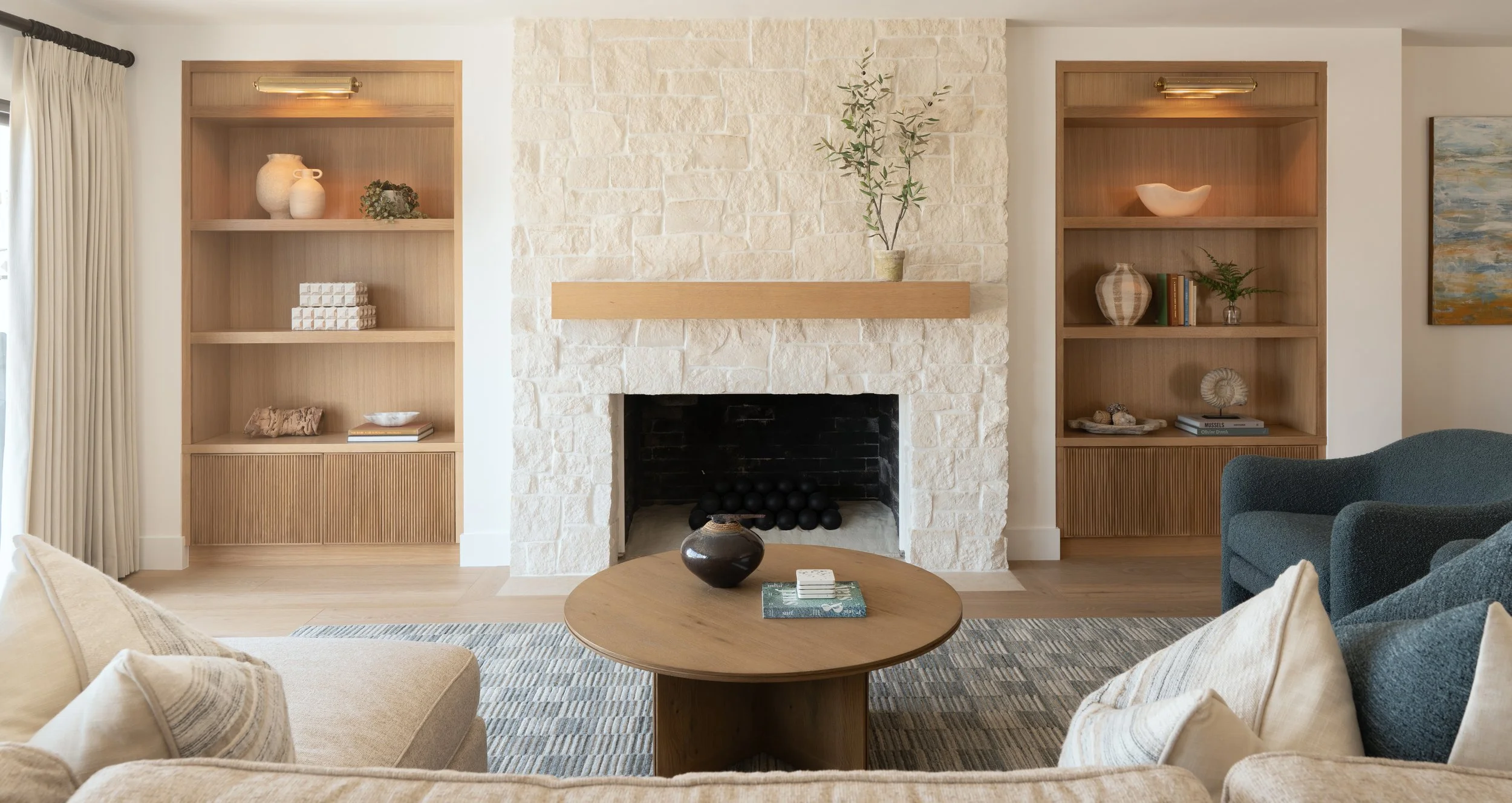 Coastal living room with custom built-in shelving and stone fireplace remodel in Newport Beach