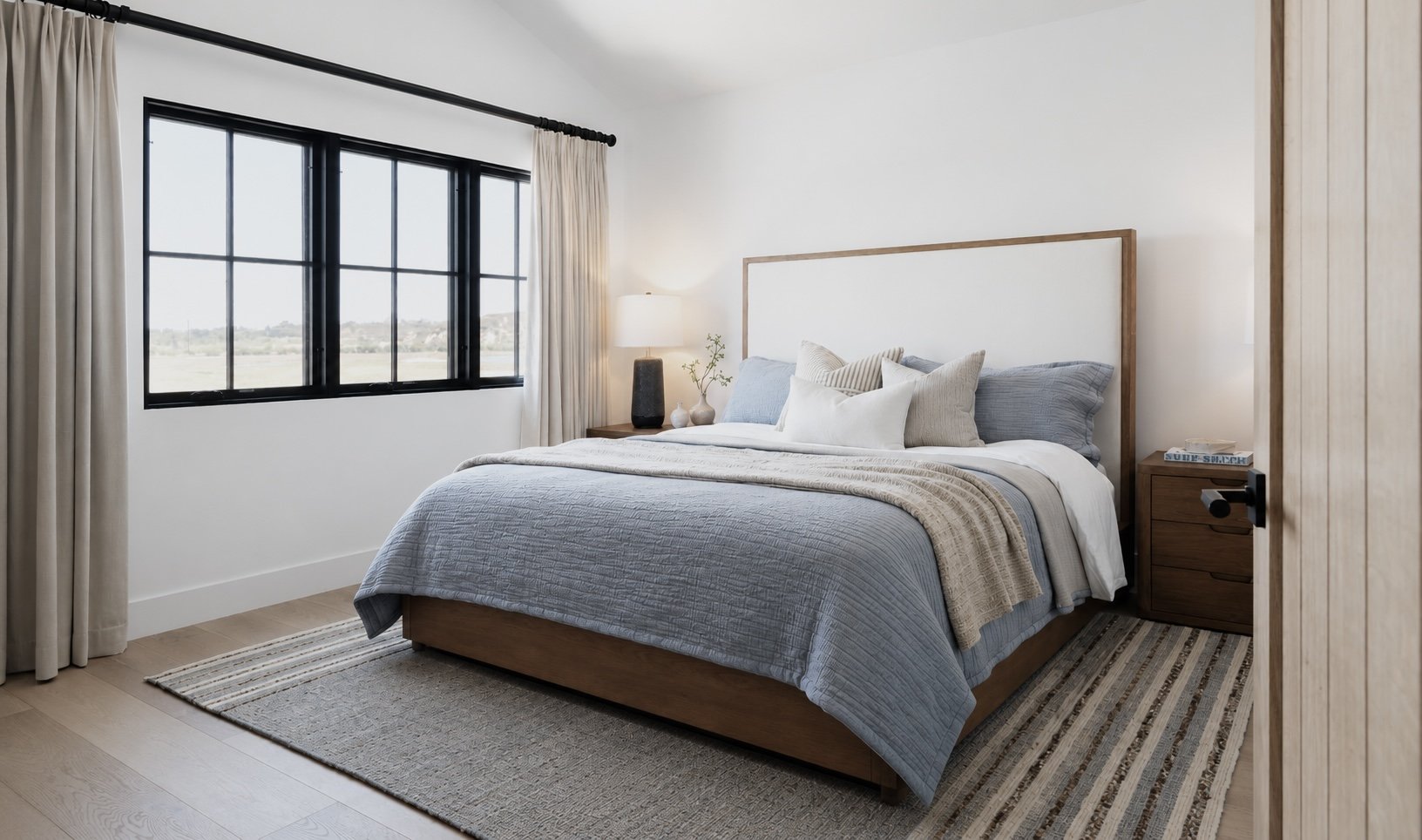 Relaxed coastal primary/master bedroom with blue bedding in Newport Beach