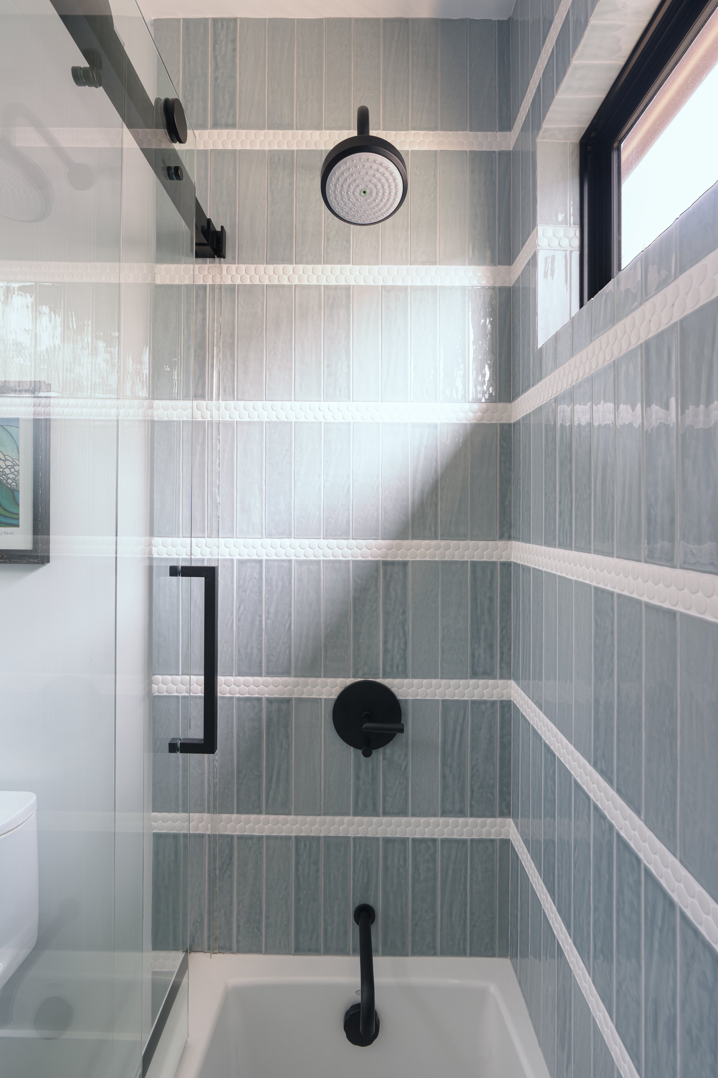 Beachy blue guest bathroom shower remodel with black accents in Newport Beach, CA