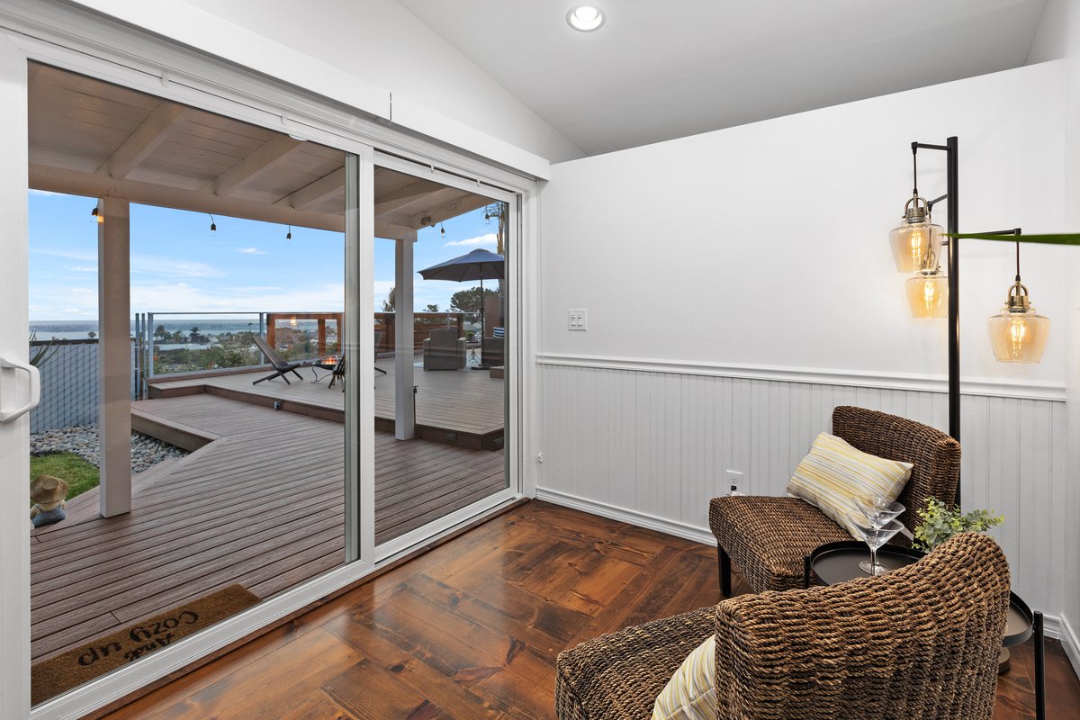 Interior of a cozy room with a sliding glass door leading to an outdoor deck.