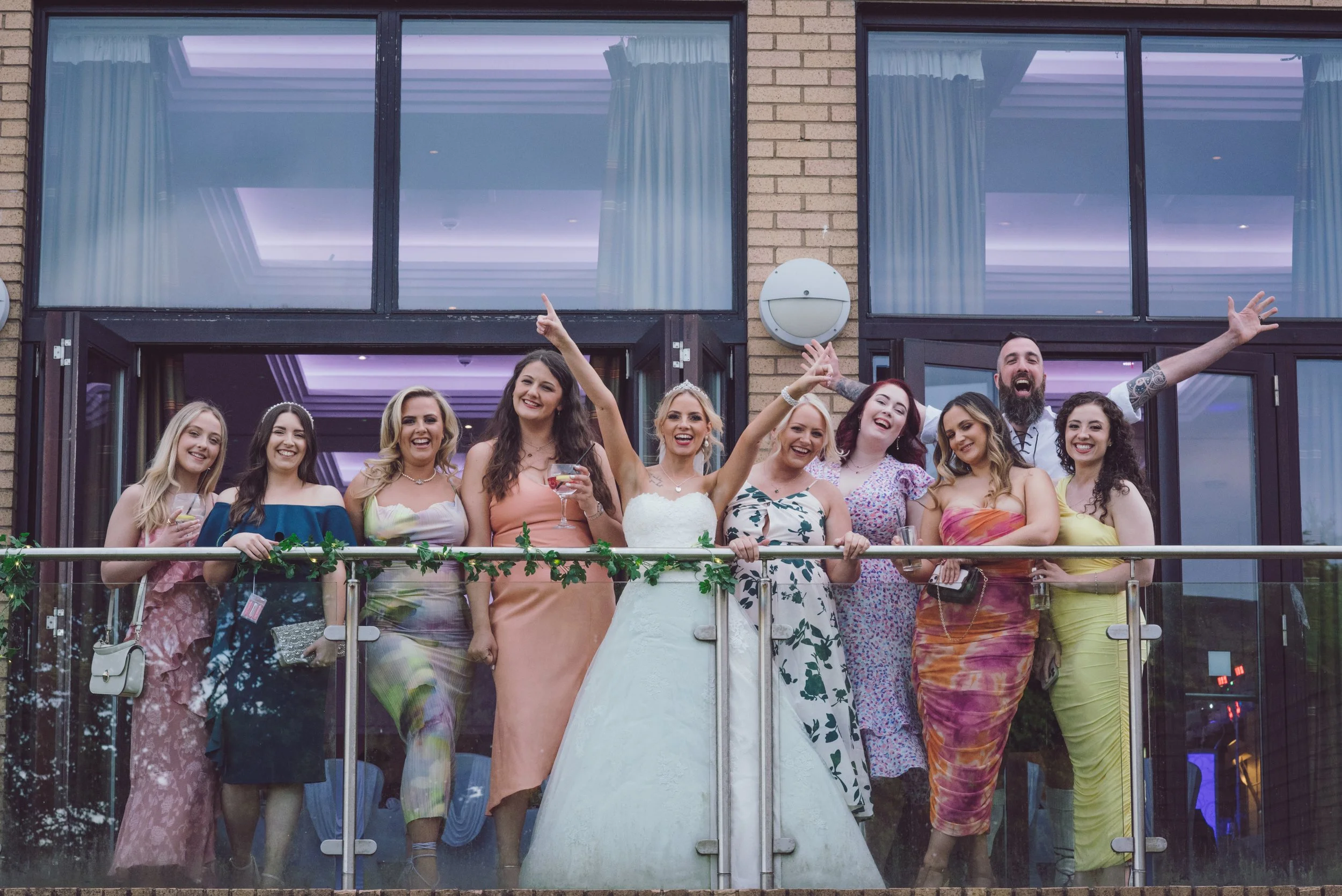 Bride celebrating with her friends and wedding guests on the balcony