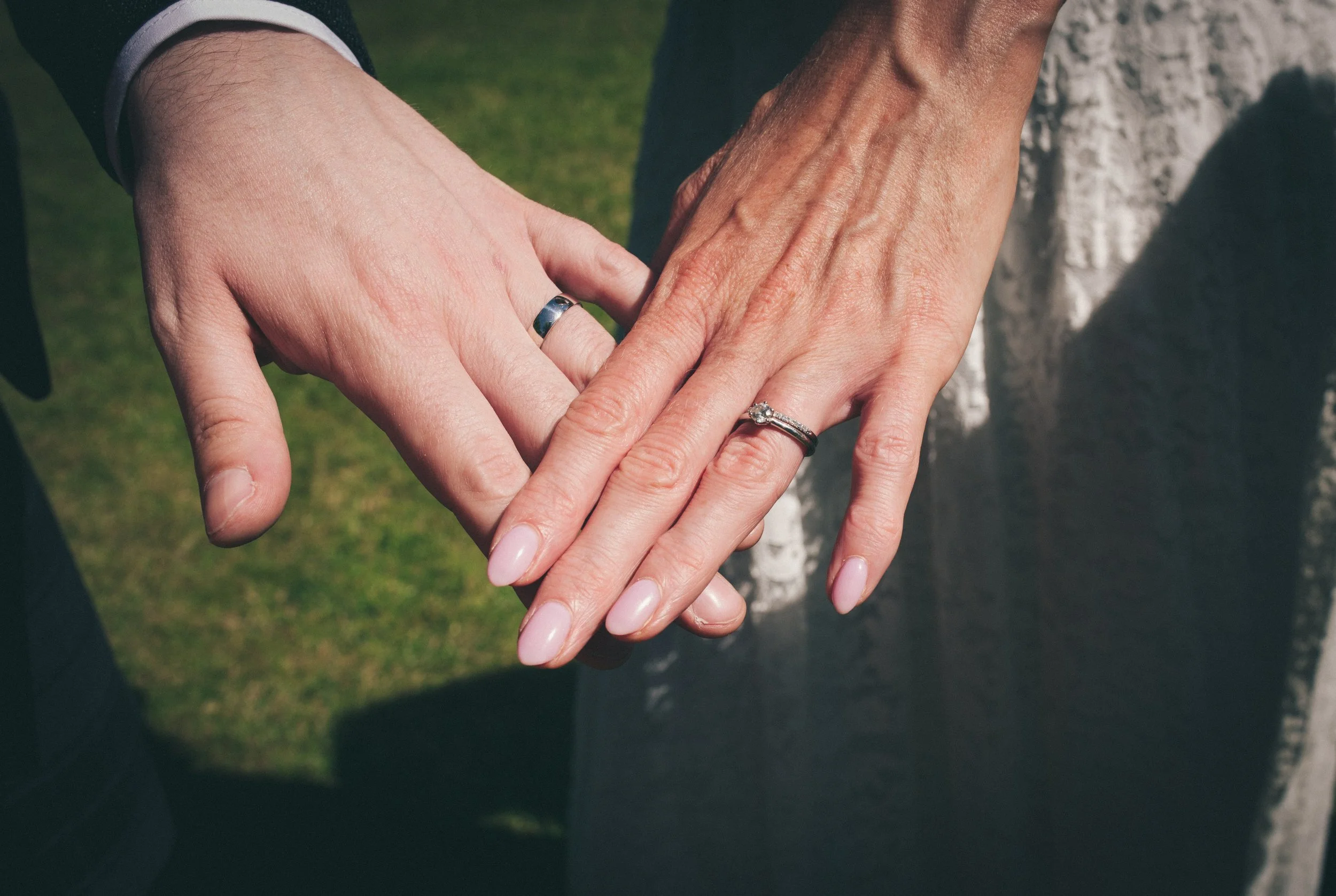 Close-up of newlyweds showing their wedding rings