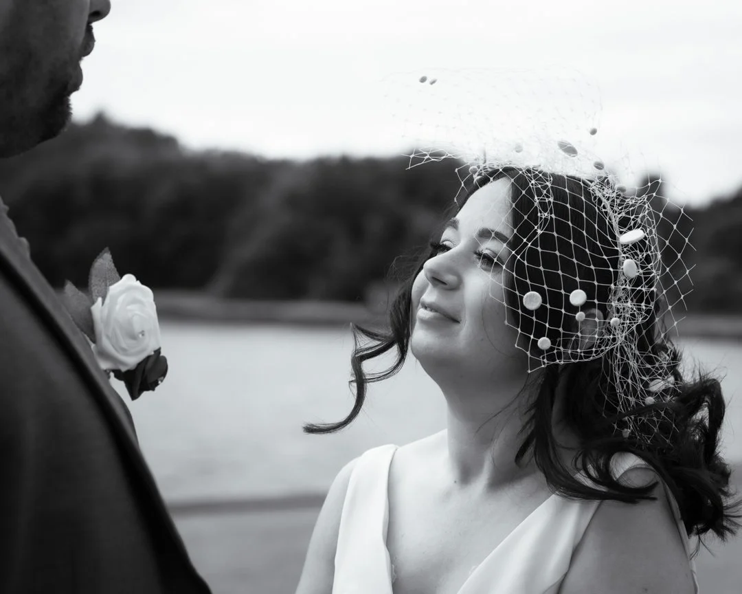 Bride smiling at her groom during a relaxed outdoor wedding portrait