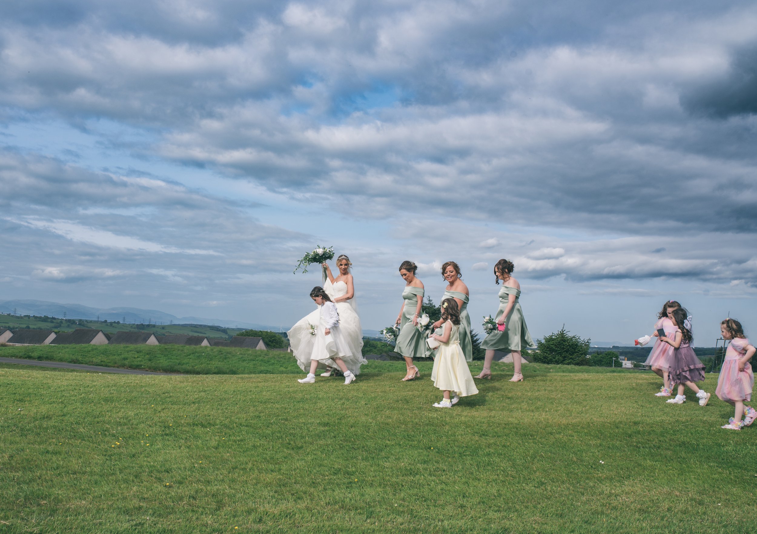 Bride walking across the grounds with her bridesmaids and flower girls