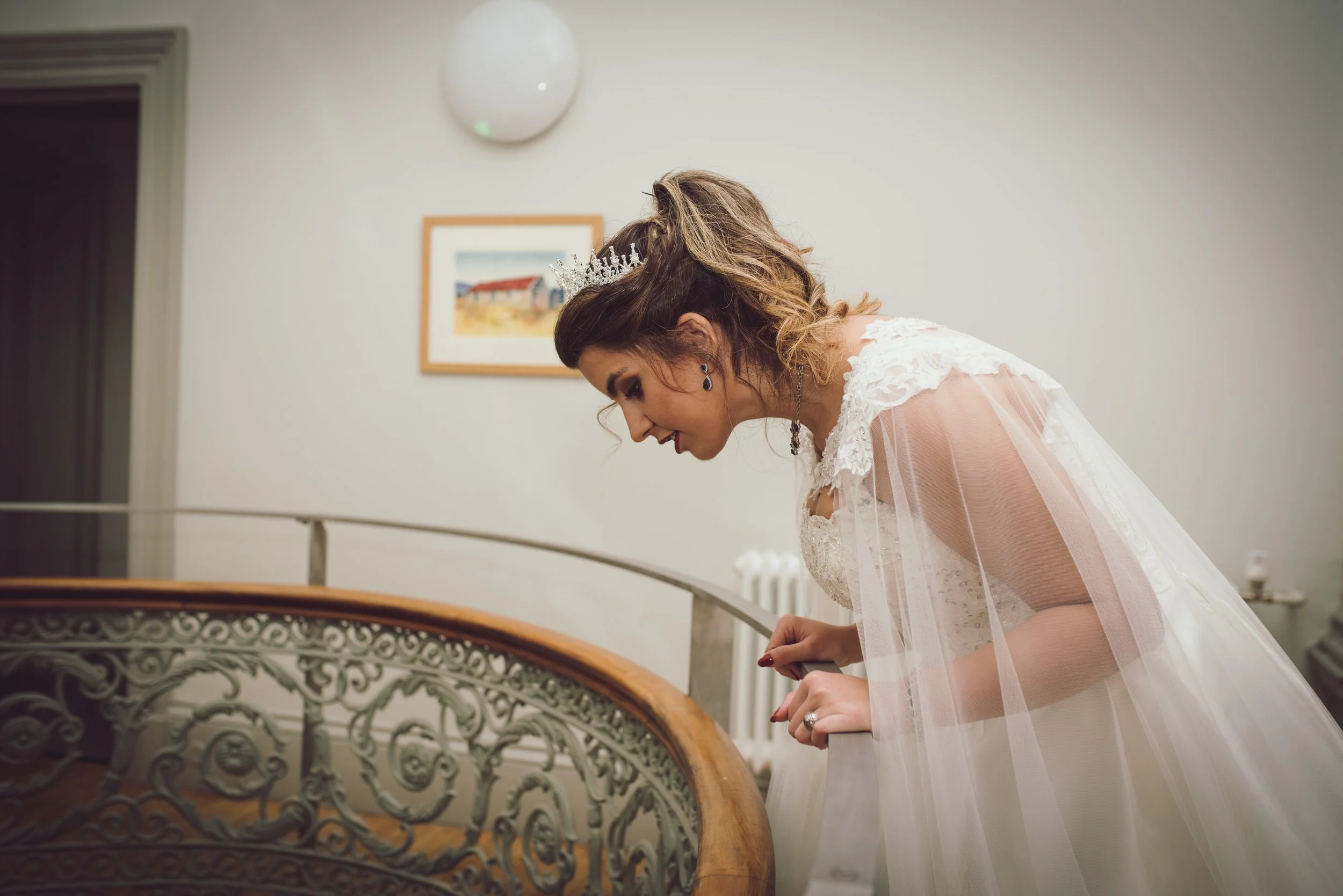 Bride looking over a staircase during her wedding