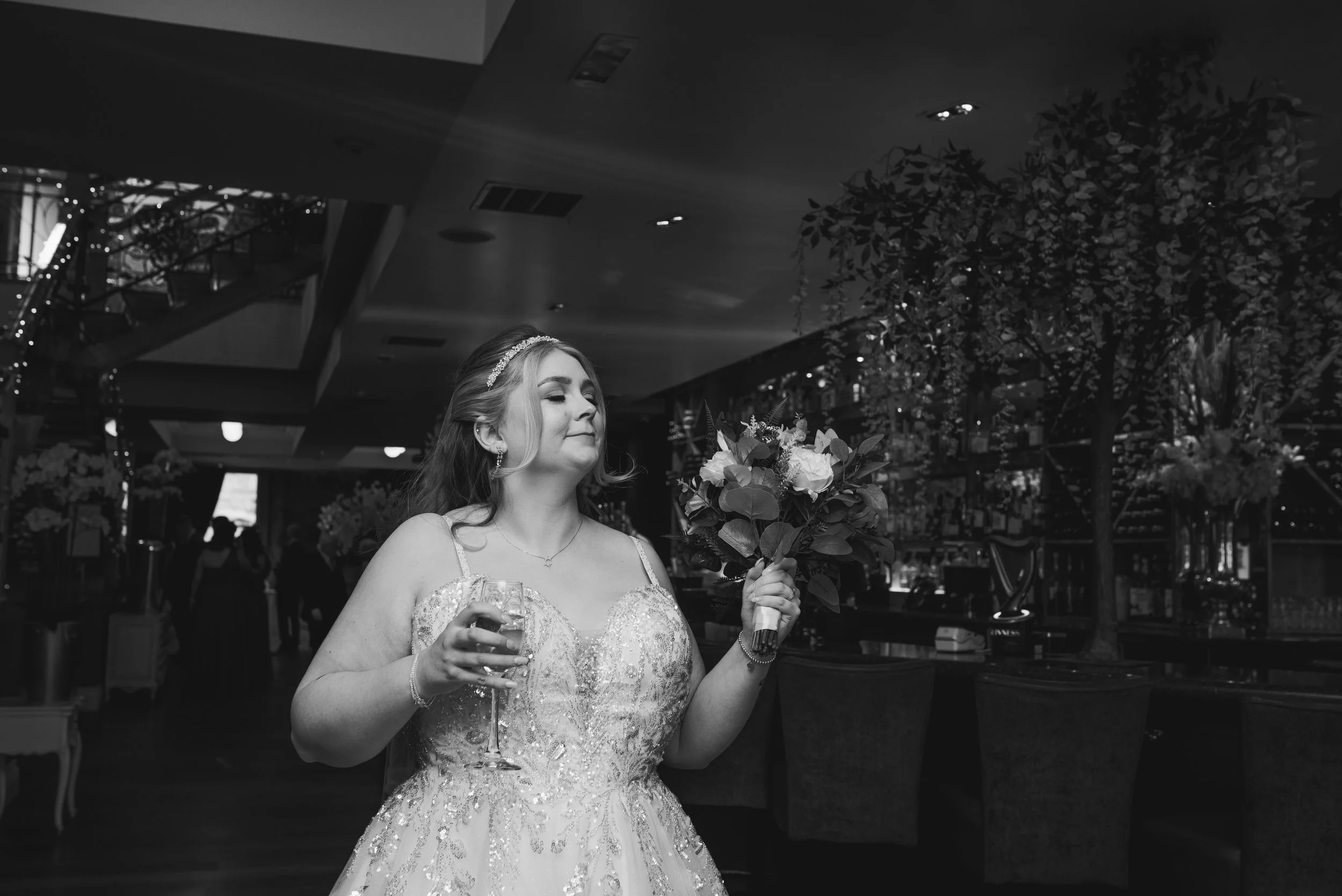 Bride holding her bouquet and champagne during her Glasgow wedding reception