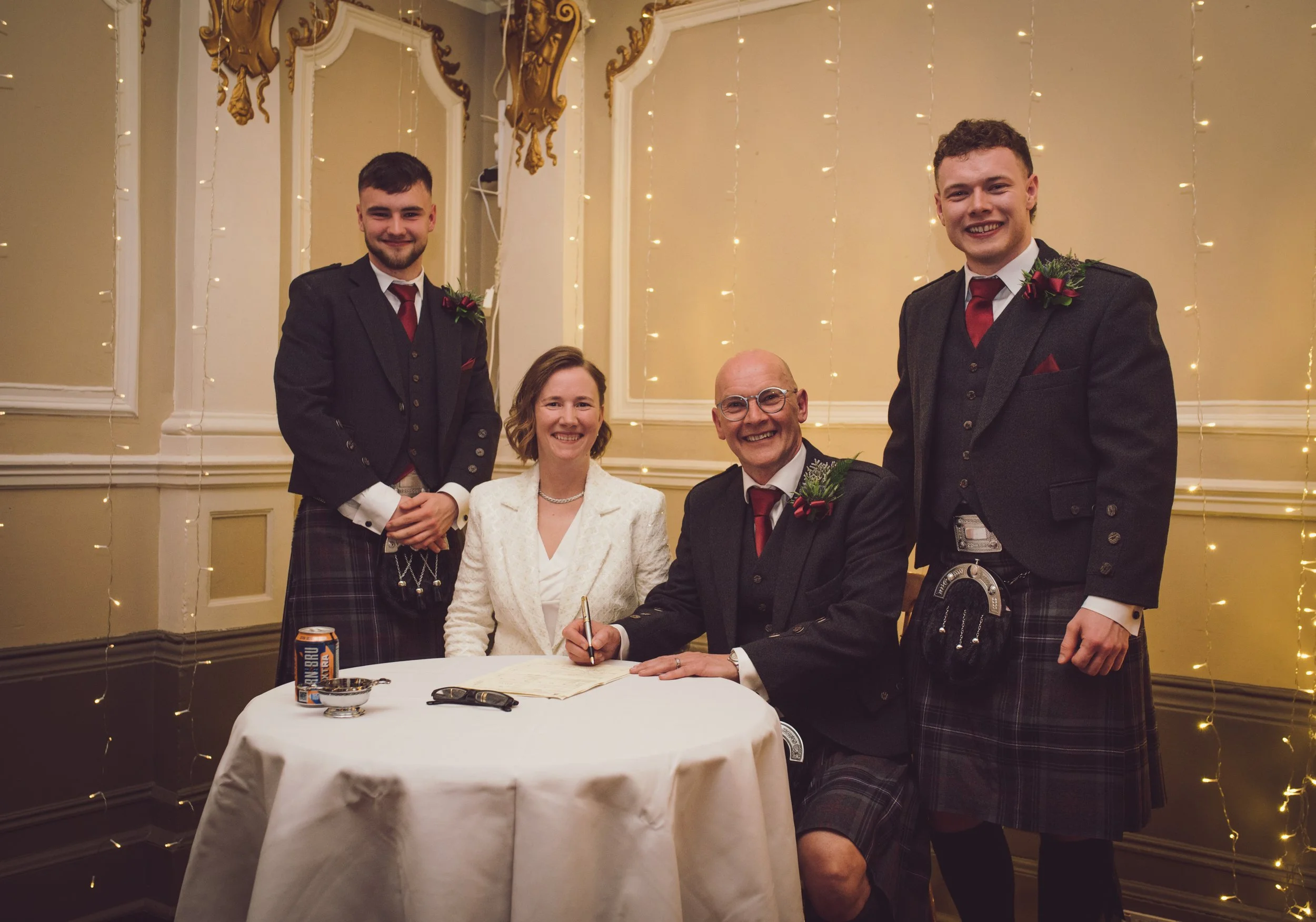 Newlyweds signing their wedding documents with family members