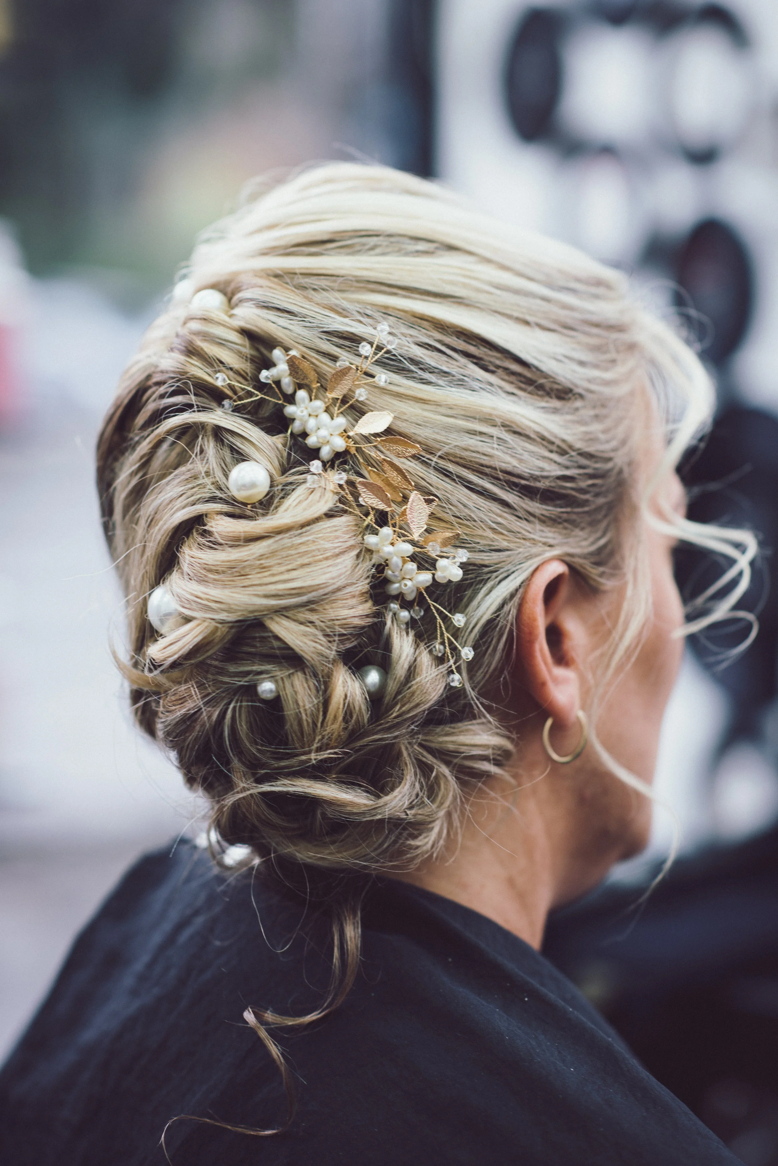 Close-up of the bride's wedding hairstyle with delicate pearl hair accessories