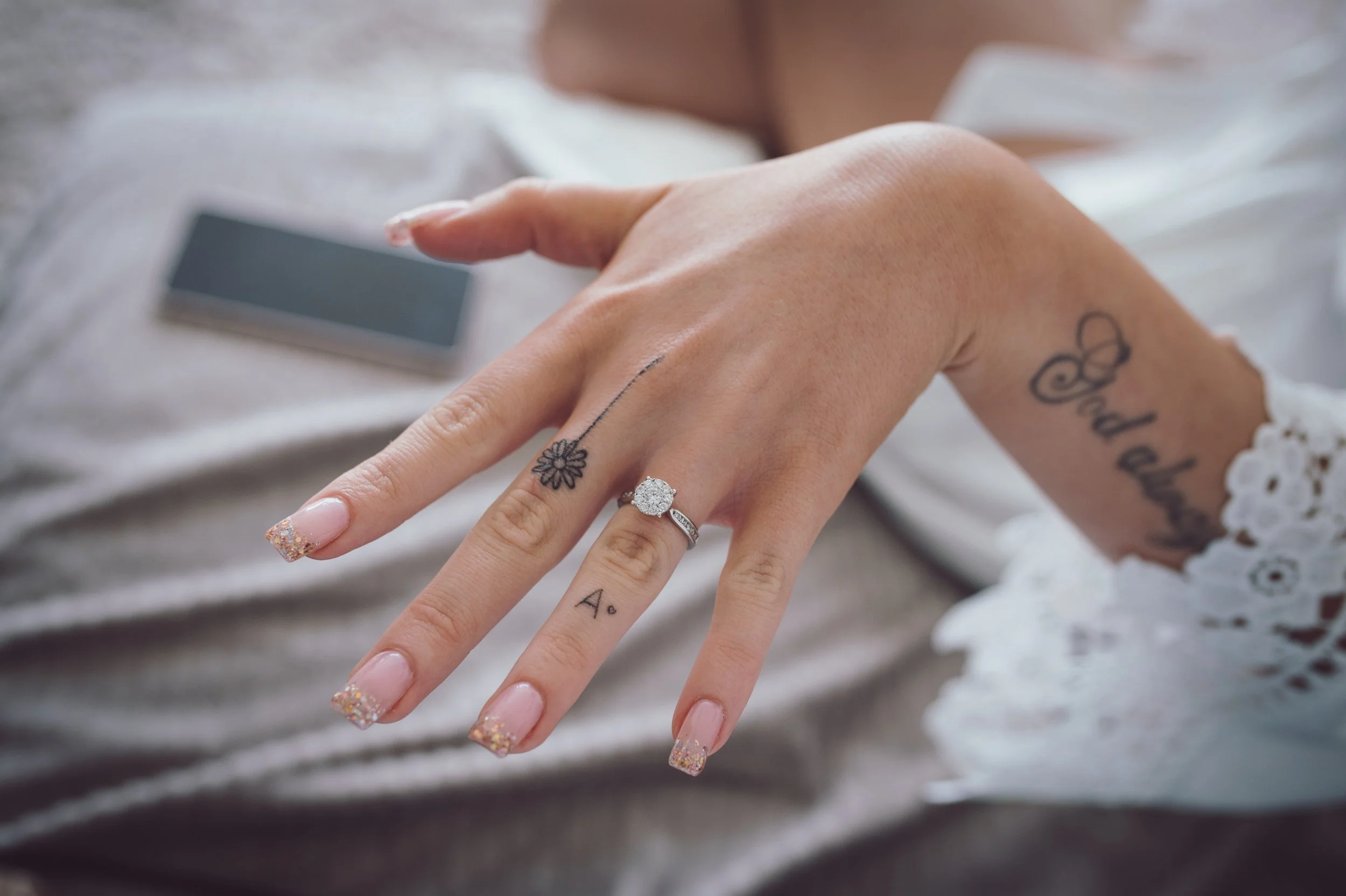 Close-up of bride's engagement ring and manicured hands during wedding preparations