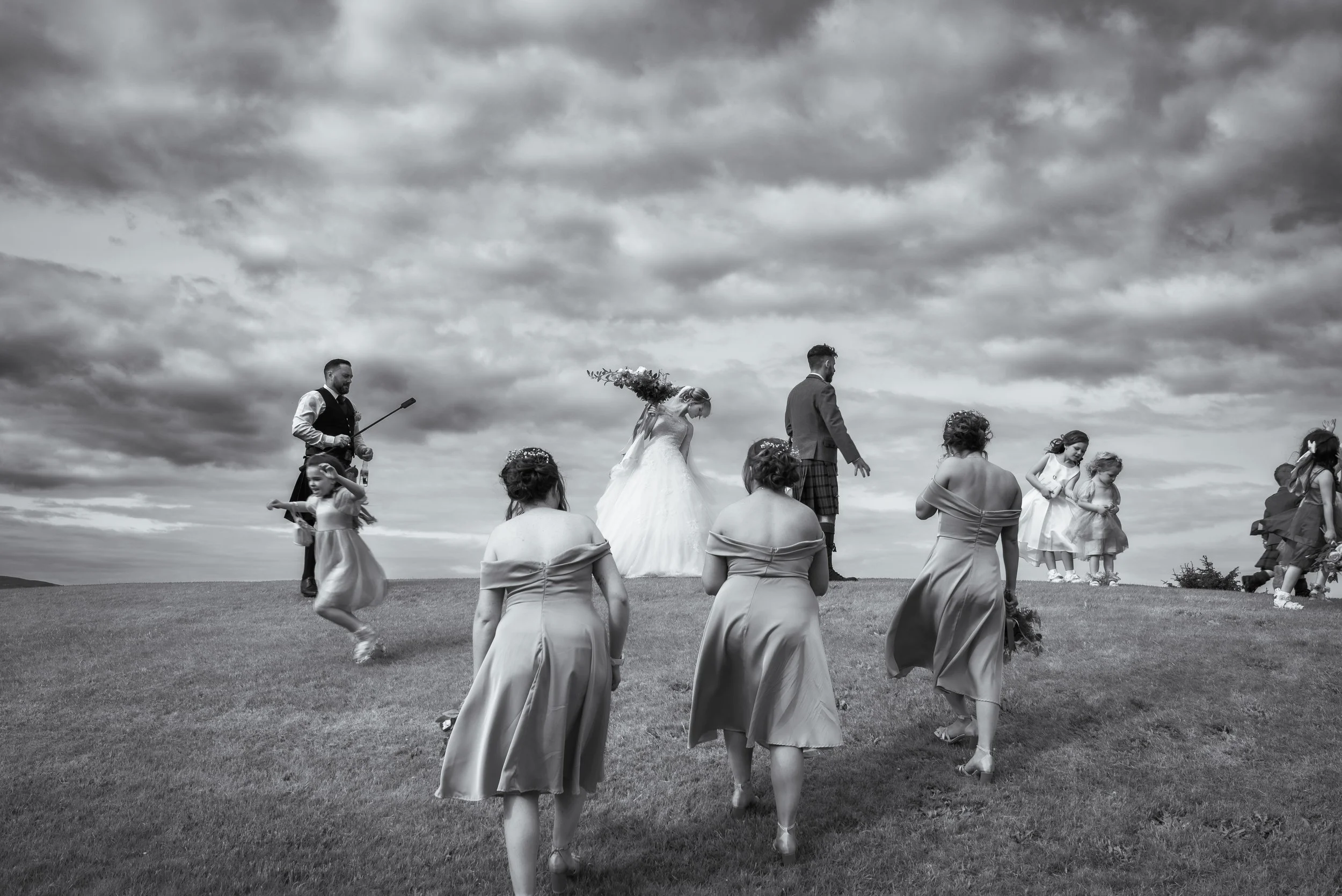 Bride and groom walking across the grounds with their wedding party