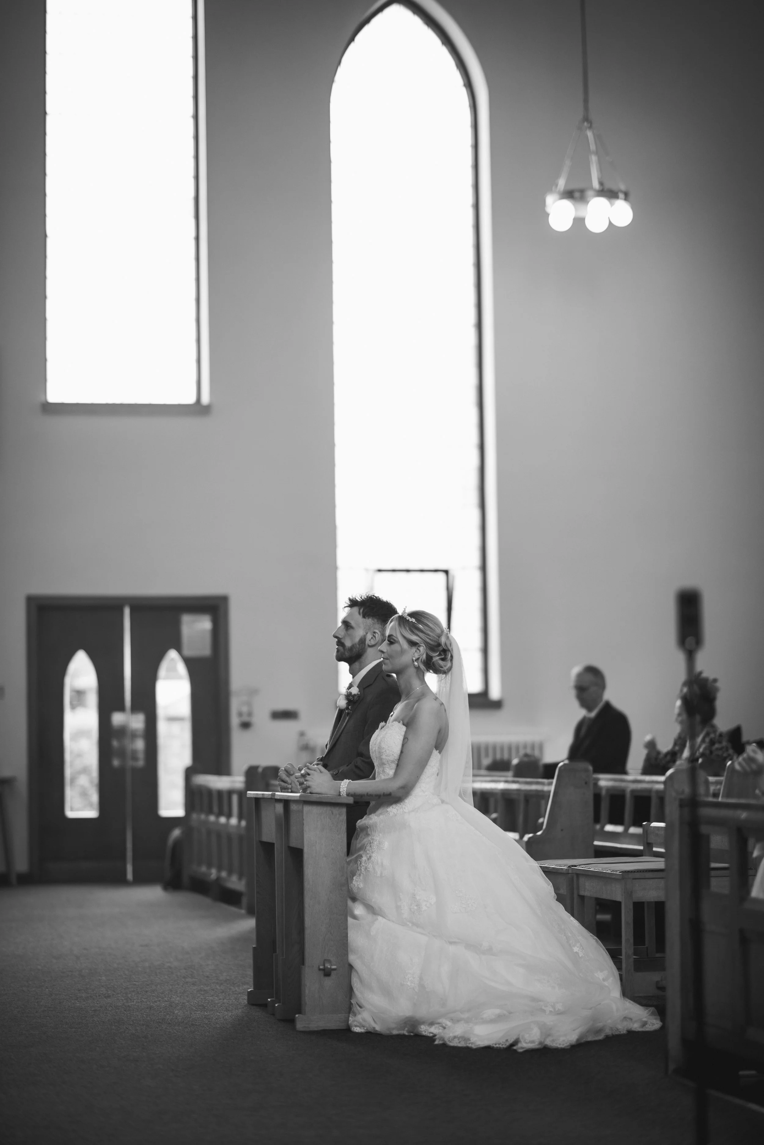 Bride and groom kneeling together during their wedding ceremony