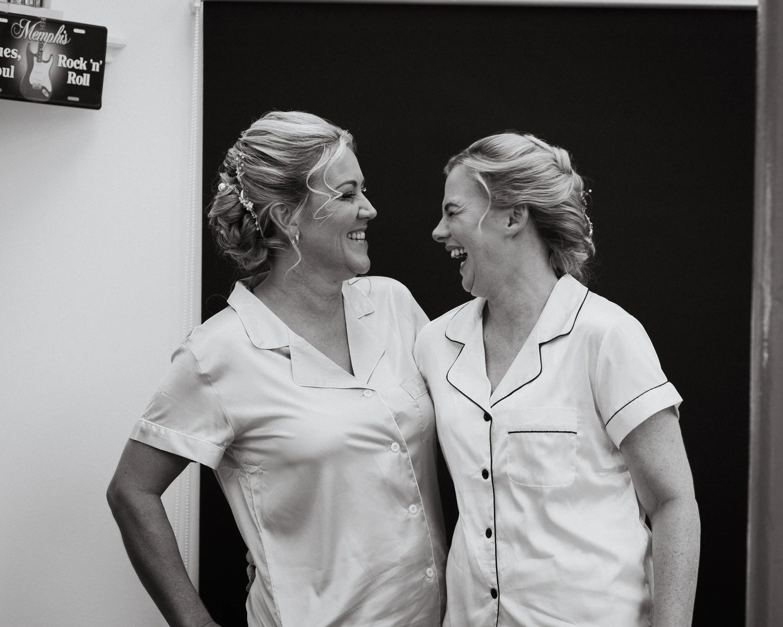 Bride and bridesmaid sharing a laugh while getting ready for the wedding