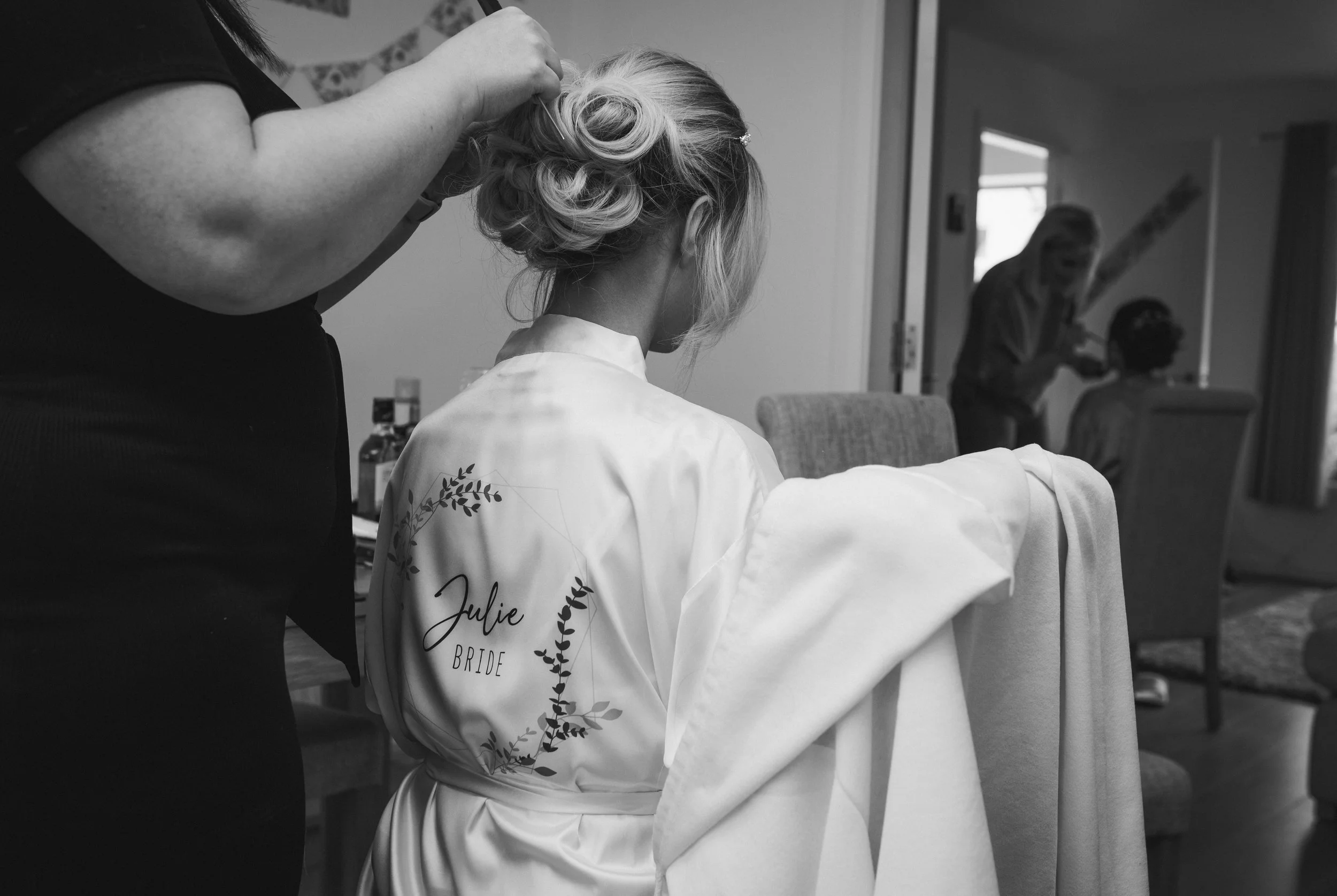 Bride having her hair styled during relaxed wedding preparations