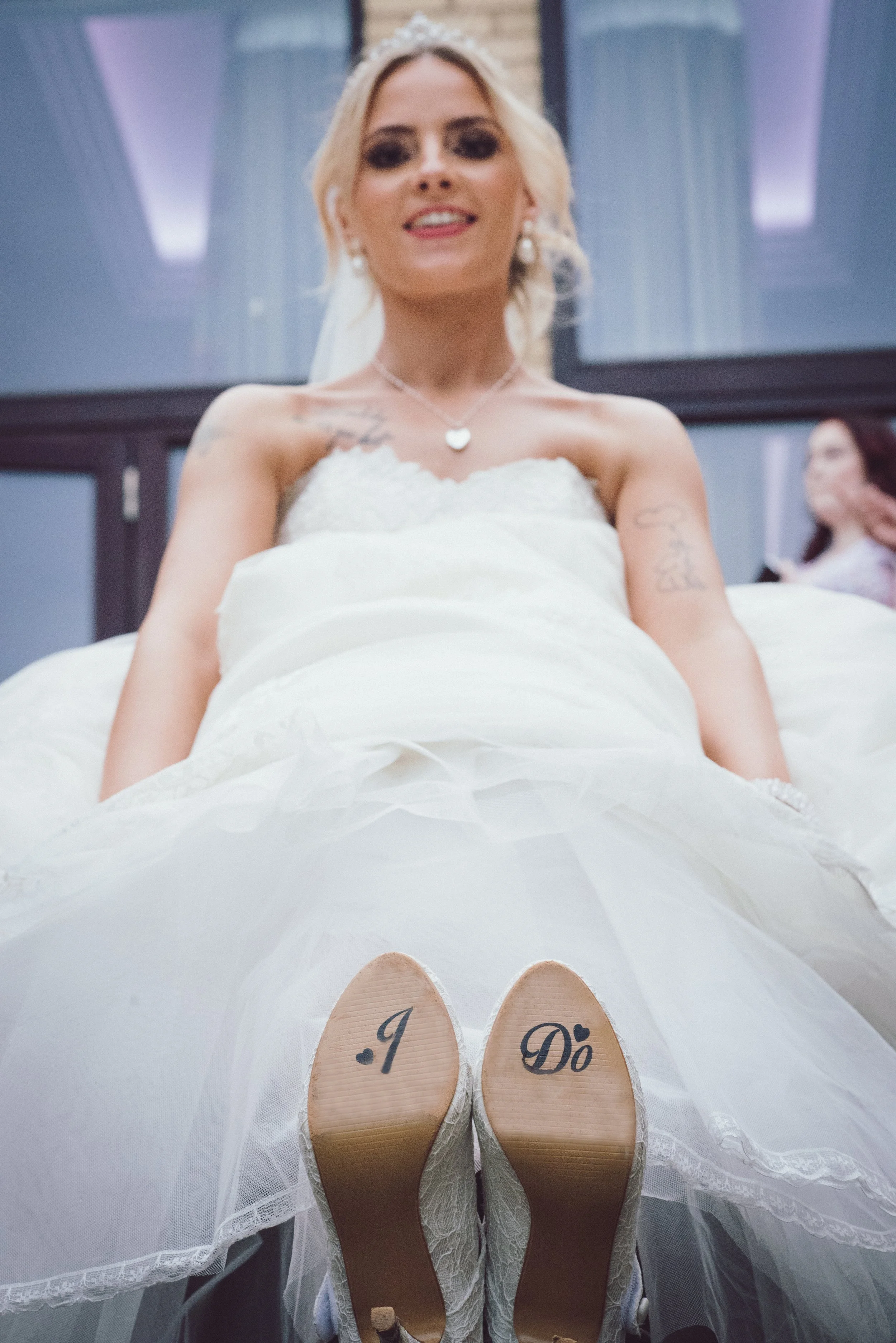 Bride relaxing in her wedding dress with personalised shoes