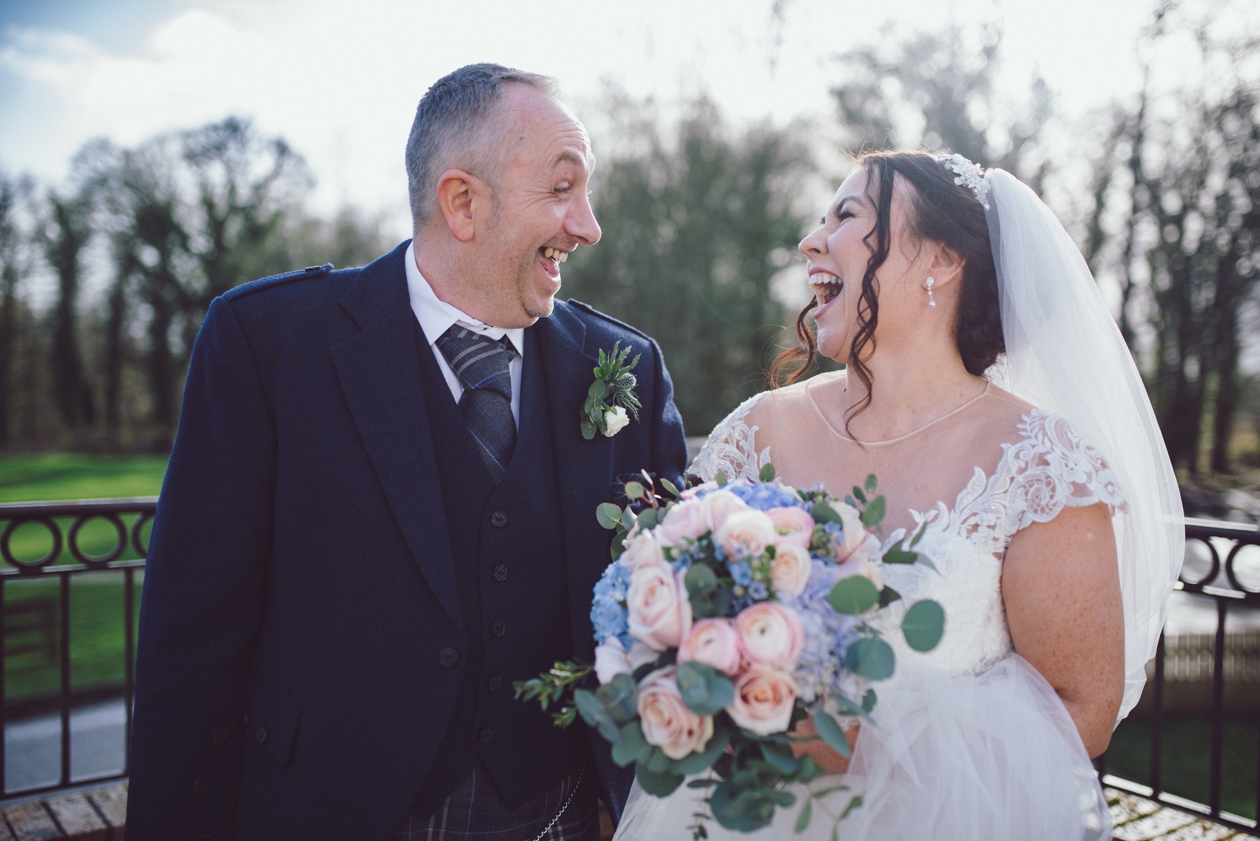 Bride and groom laughing together during their Glasgow wedding