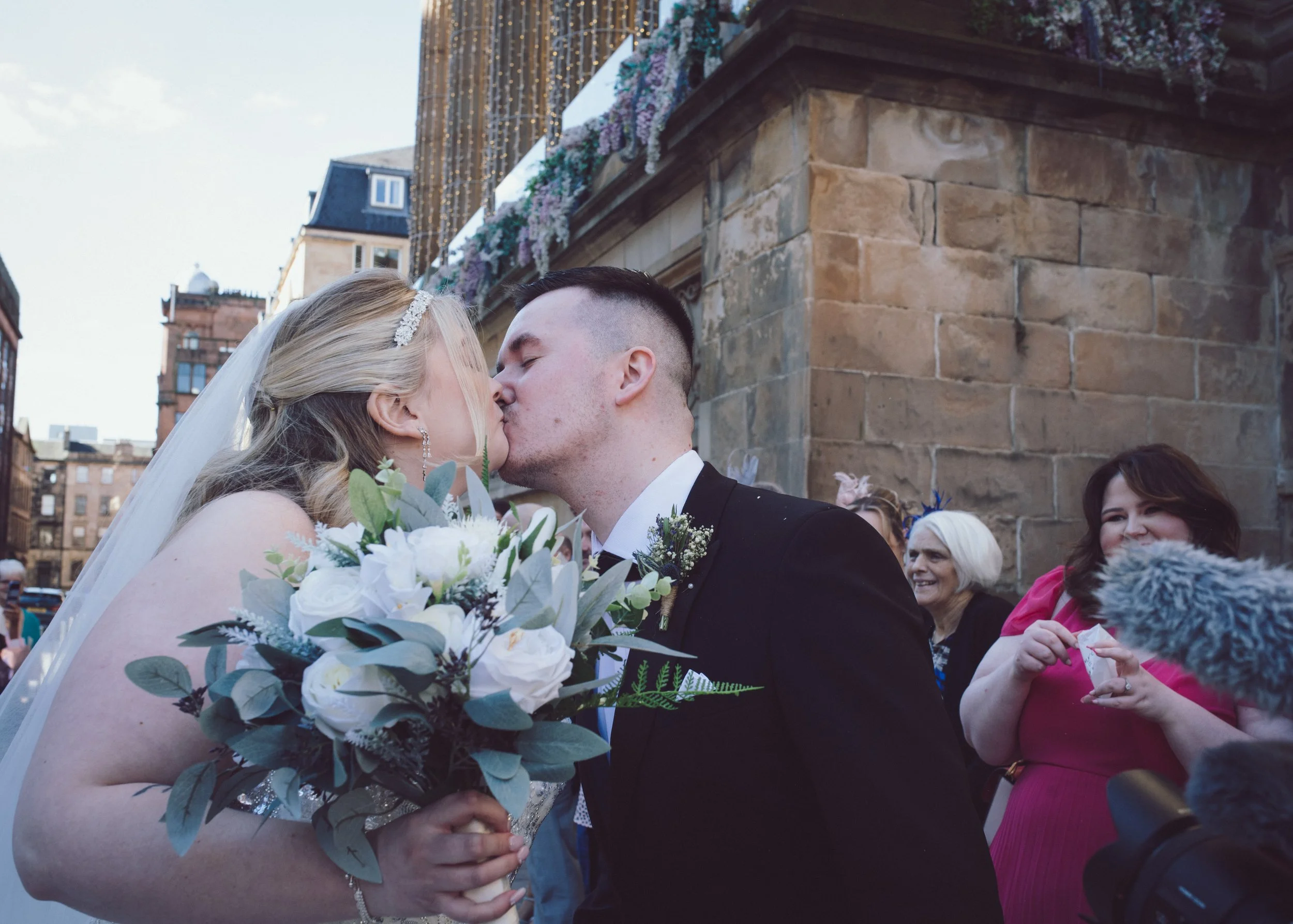 Newlywed couple sharing a kiss outside Citation in Glasgow city centre