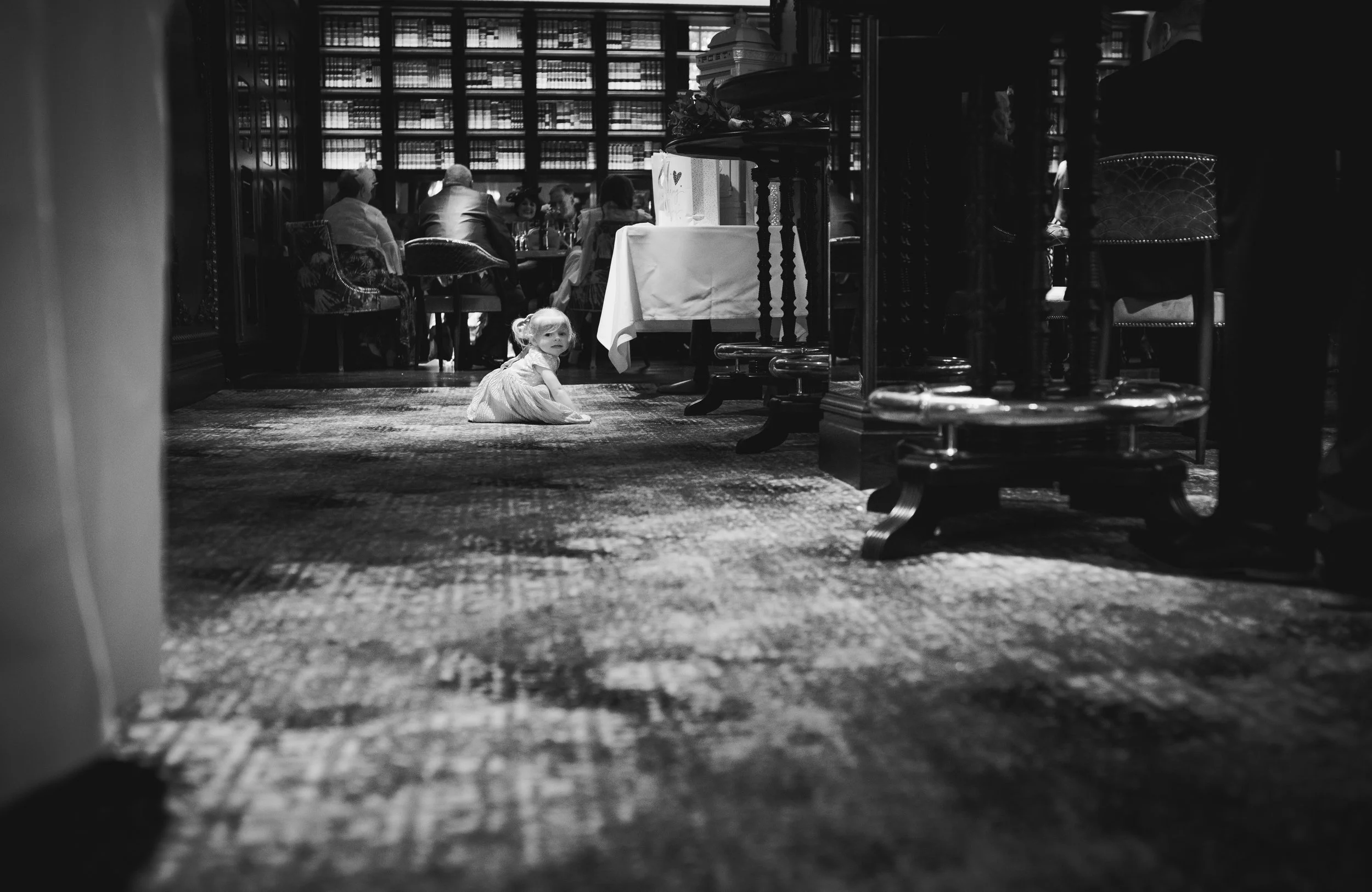 Young child sitting on the floor during the wedding reception