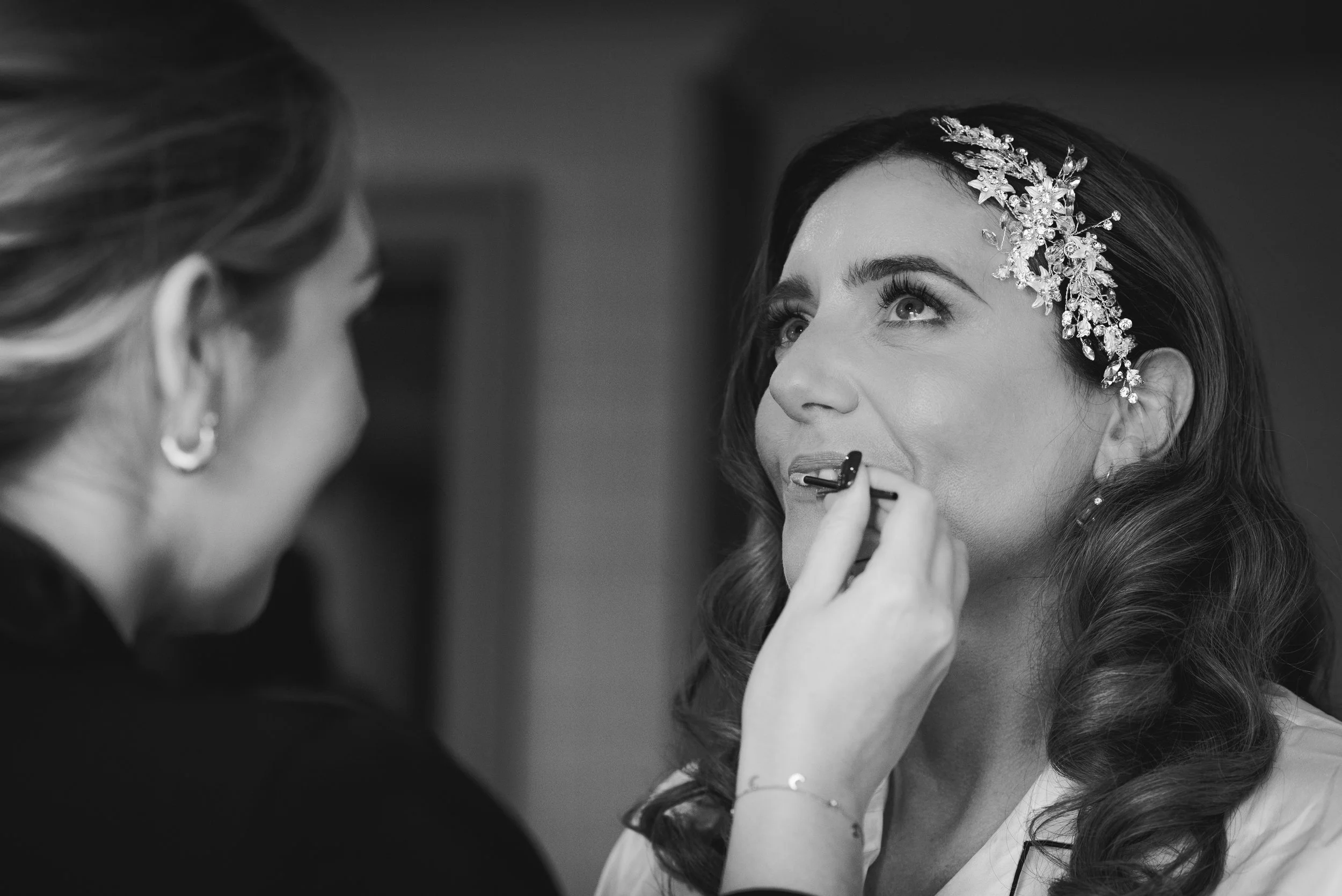 Bride having her makeup finished during relaxed wedding preparations