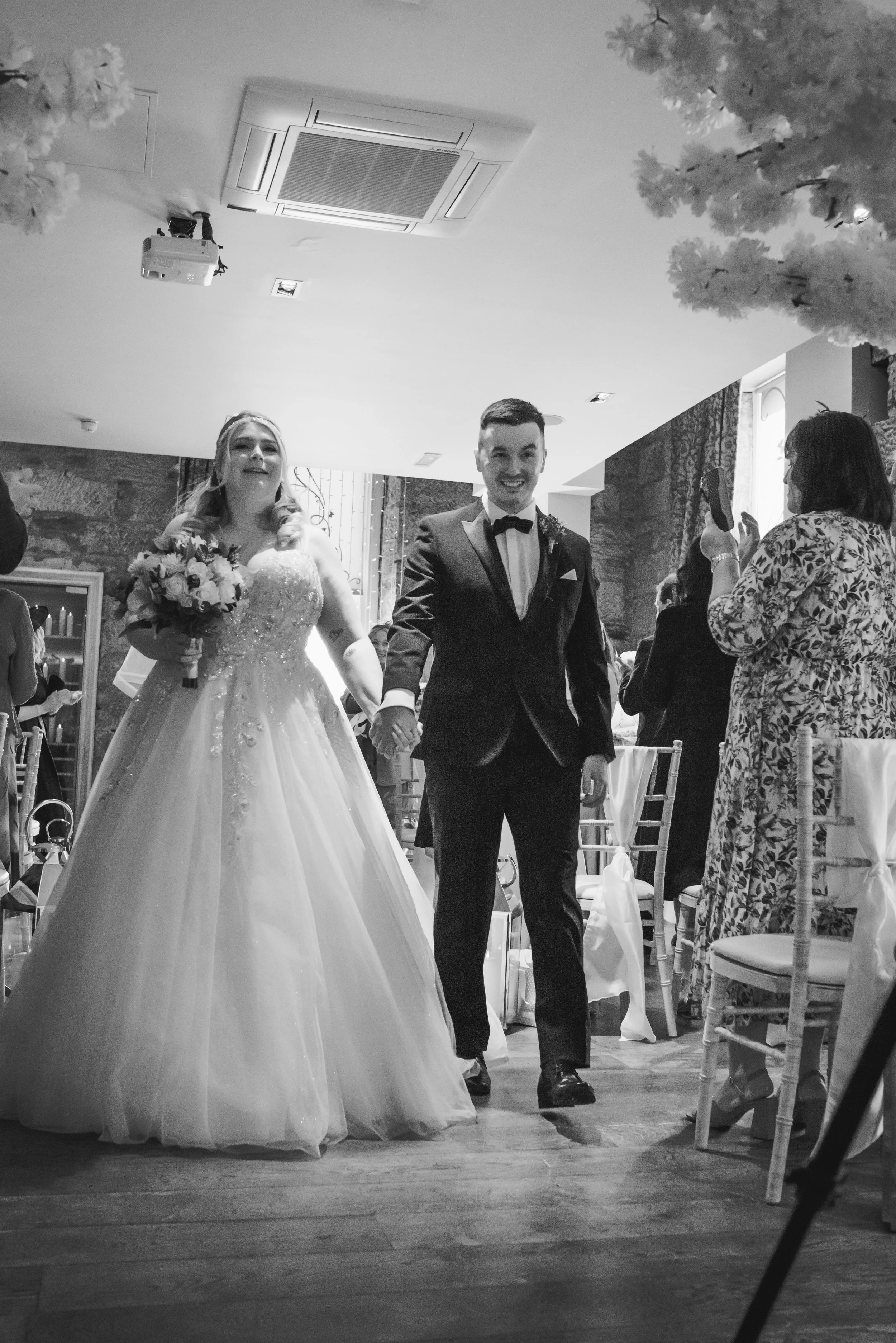 Bride and groom walking hand in hand through their Glasgow wedding ceremony