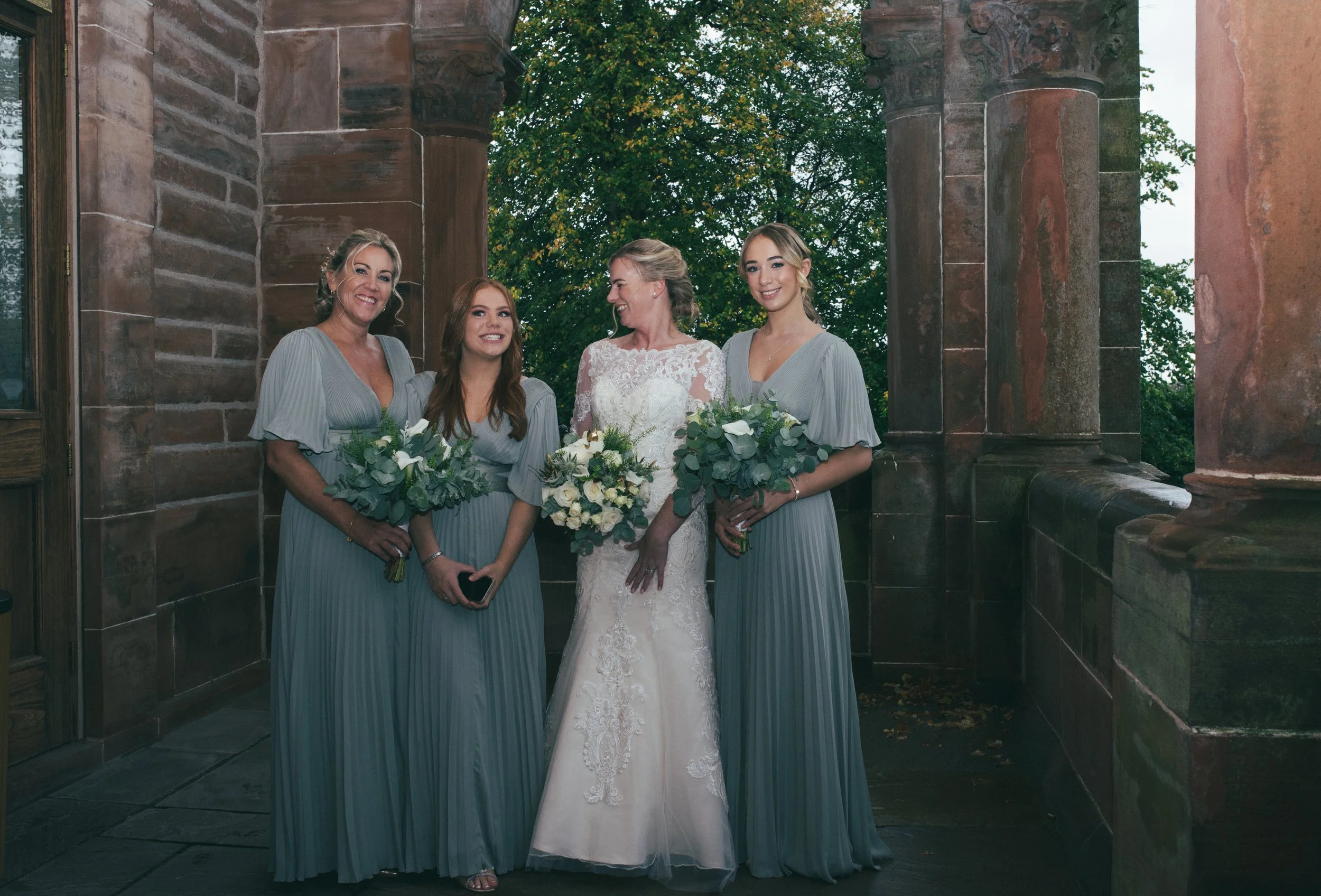 Bride standing with her bridesmaids holding their bouquets