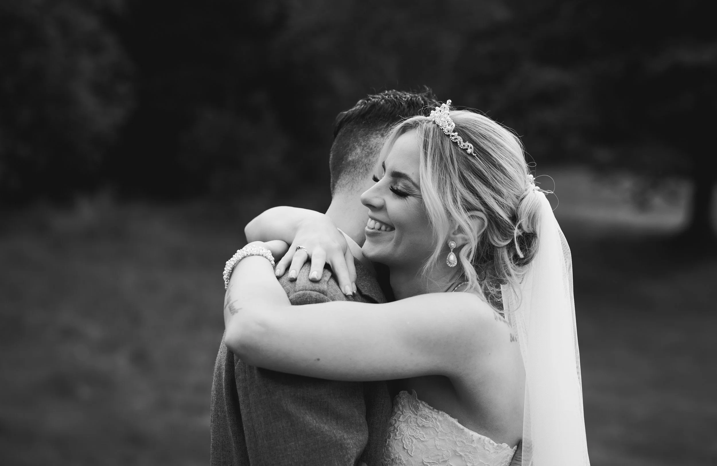 Bride embracing her groom during an intimate black and white wedding portrait
