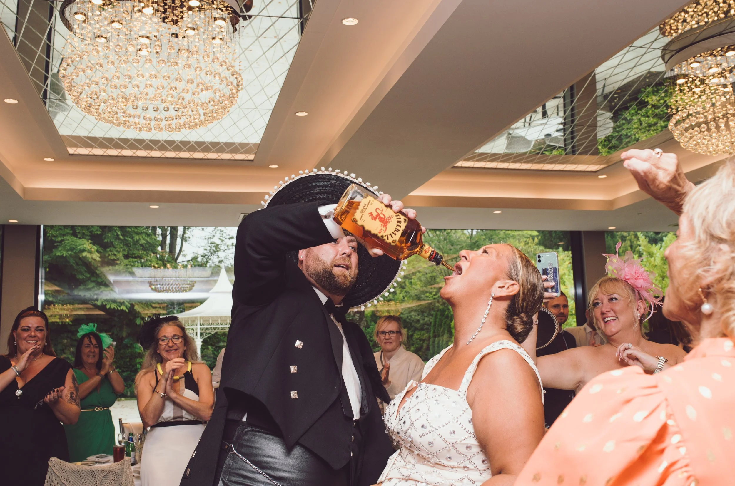 Bride and best man celebrating with friends during a lively wedding reception