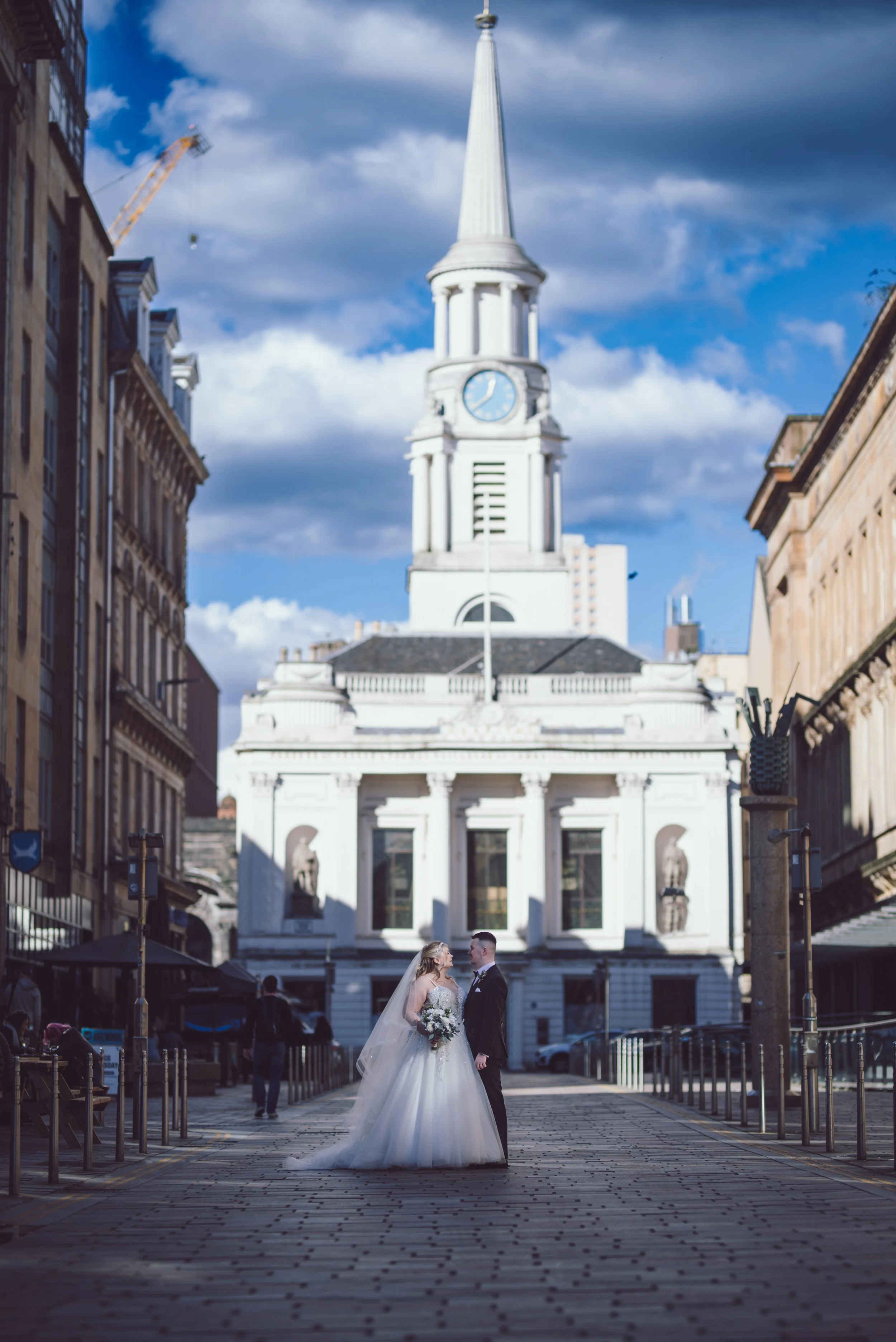 Bride and groom photographed together in Glasgow city centre with the historic architecture behind them