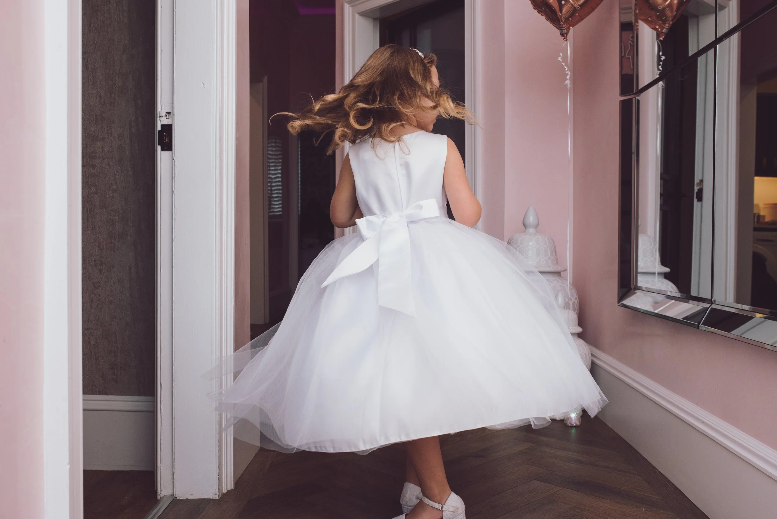 Flower girl walking through the wedding venue in her white dress