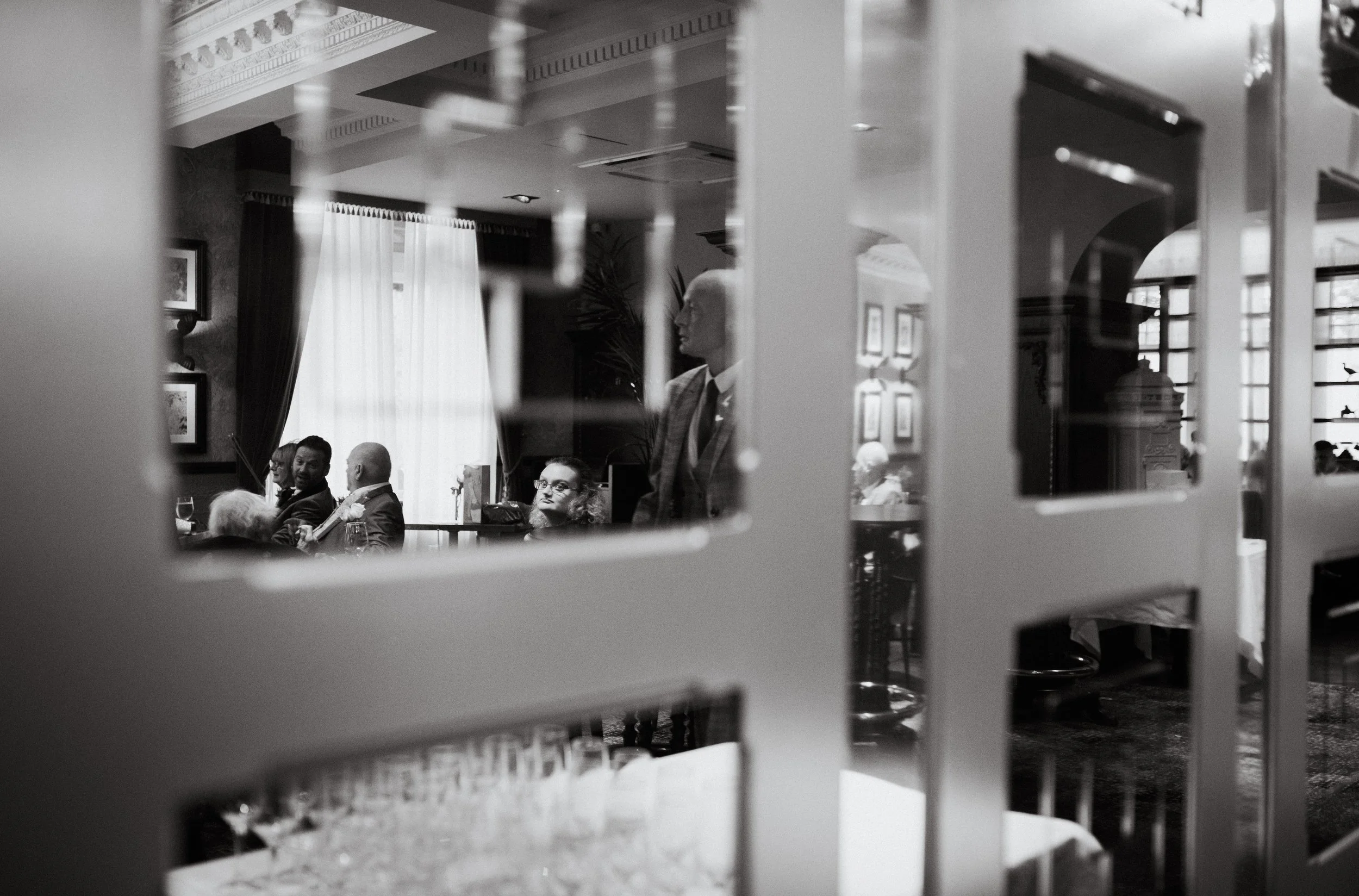 Guests and wedding reception reflected in the venue's mirrors