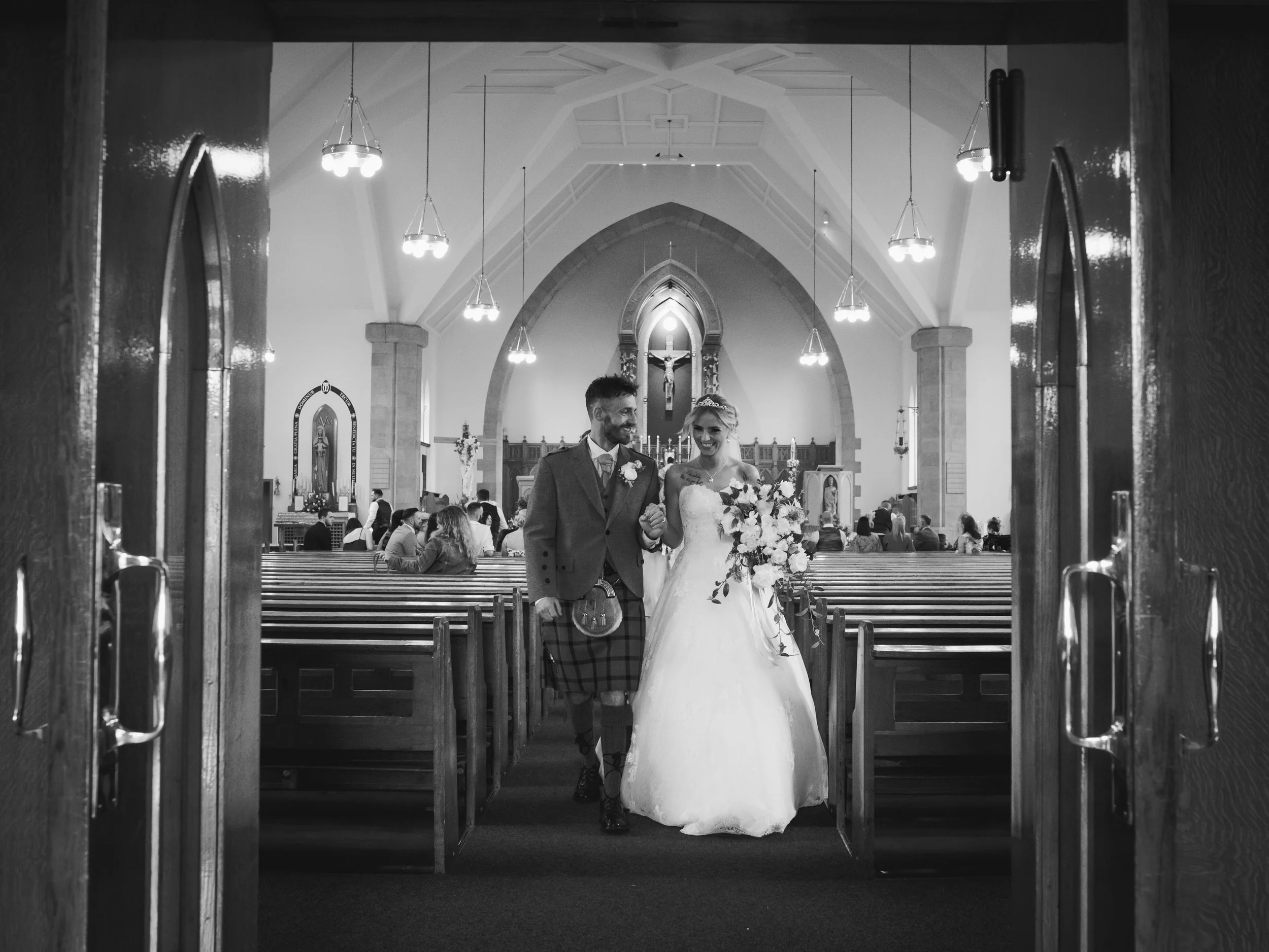 Newlywed couple walking out of their church wedding ceremony together