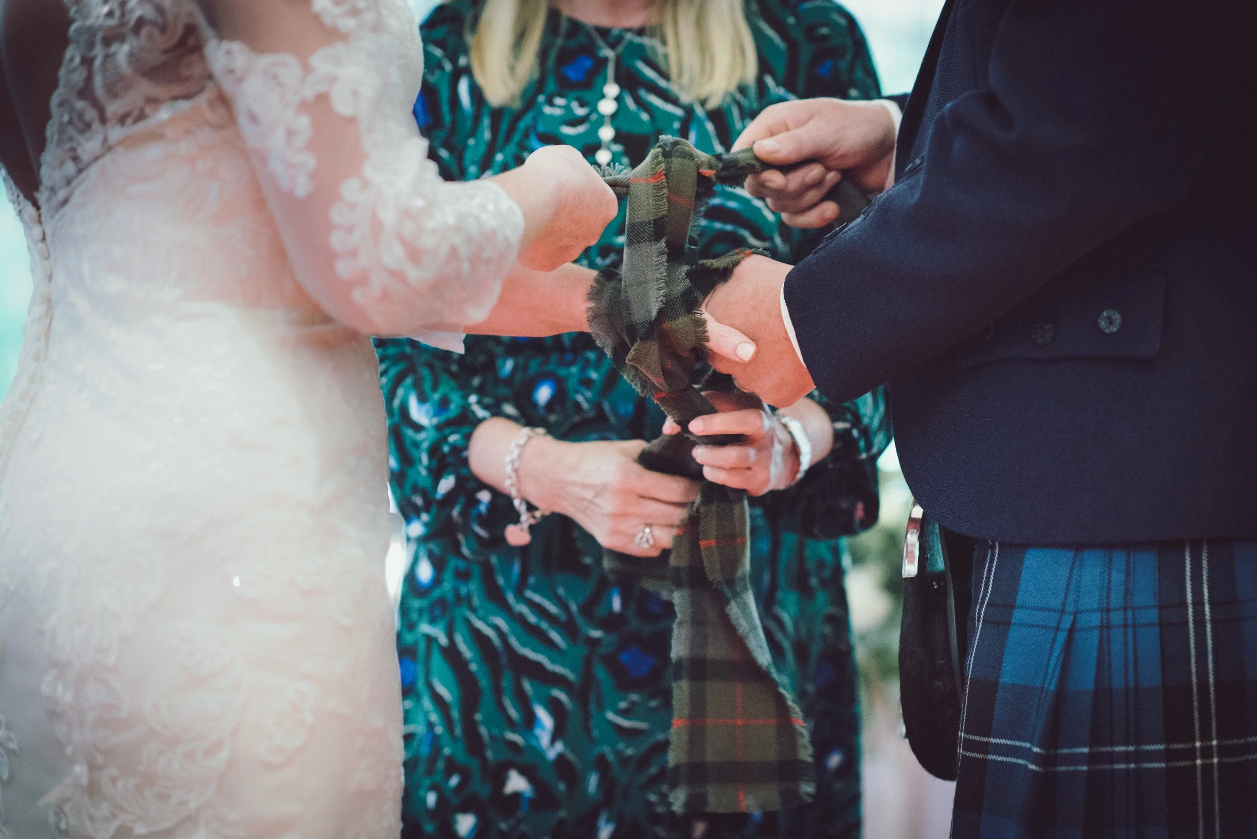 Close up of bride's wedding dress and hands