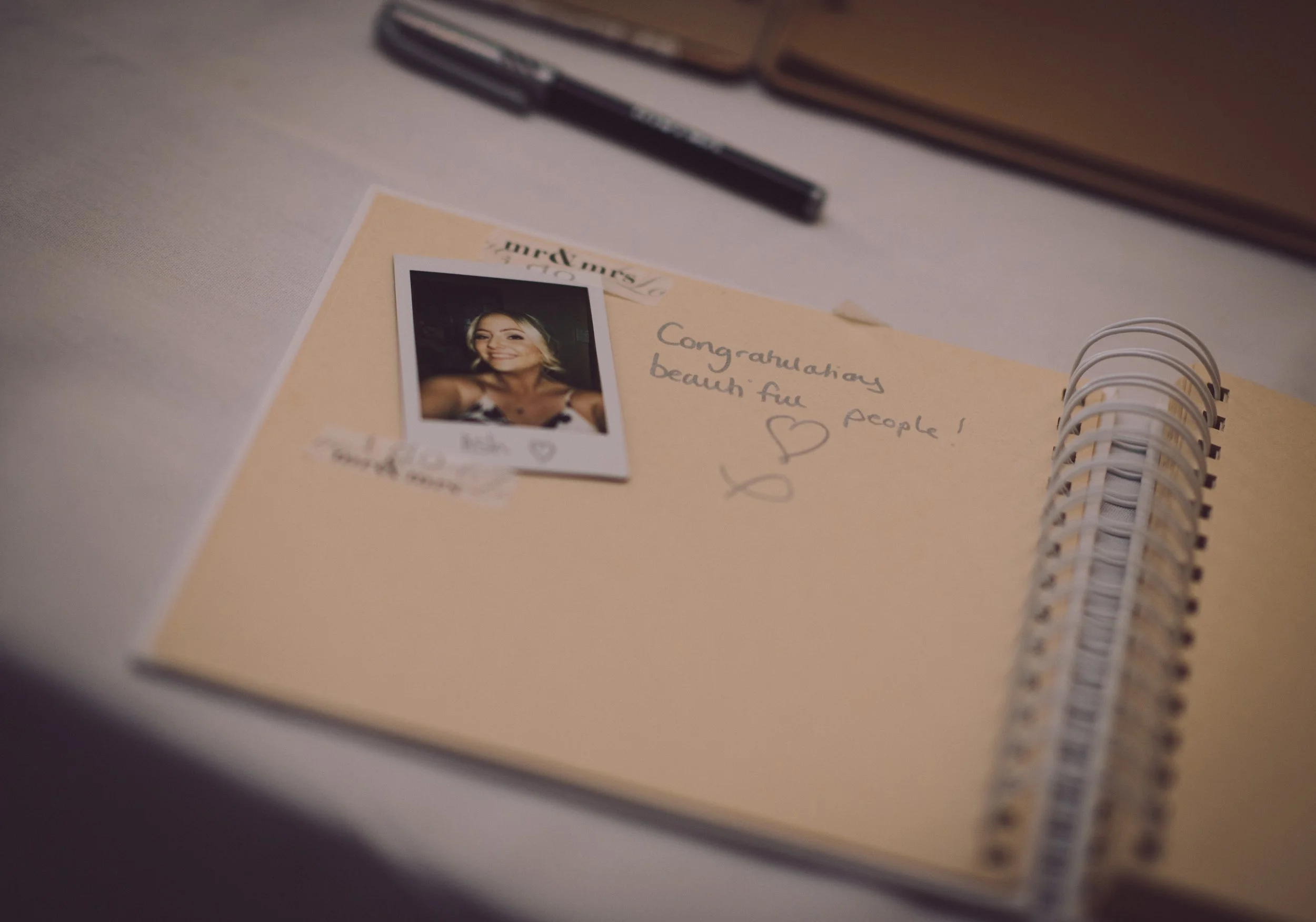 Wedding guest book with handwritten messages and a Polaroid photograph