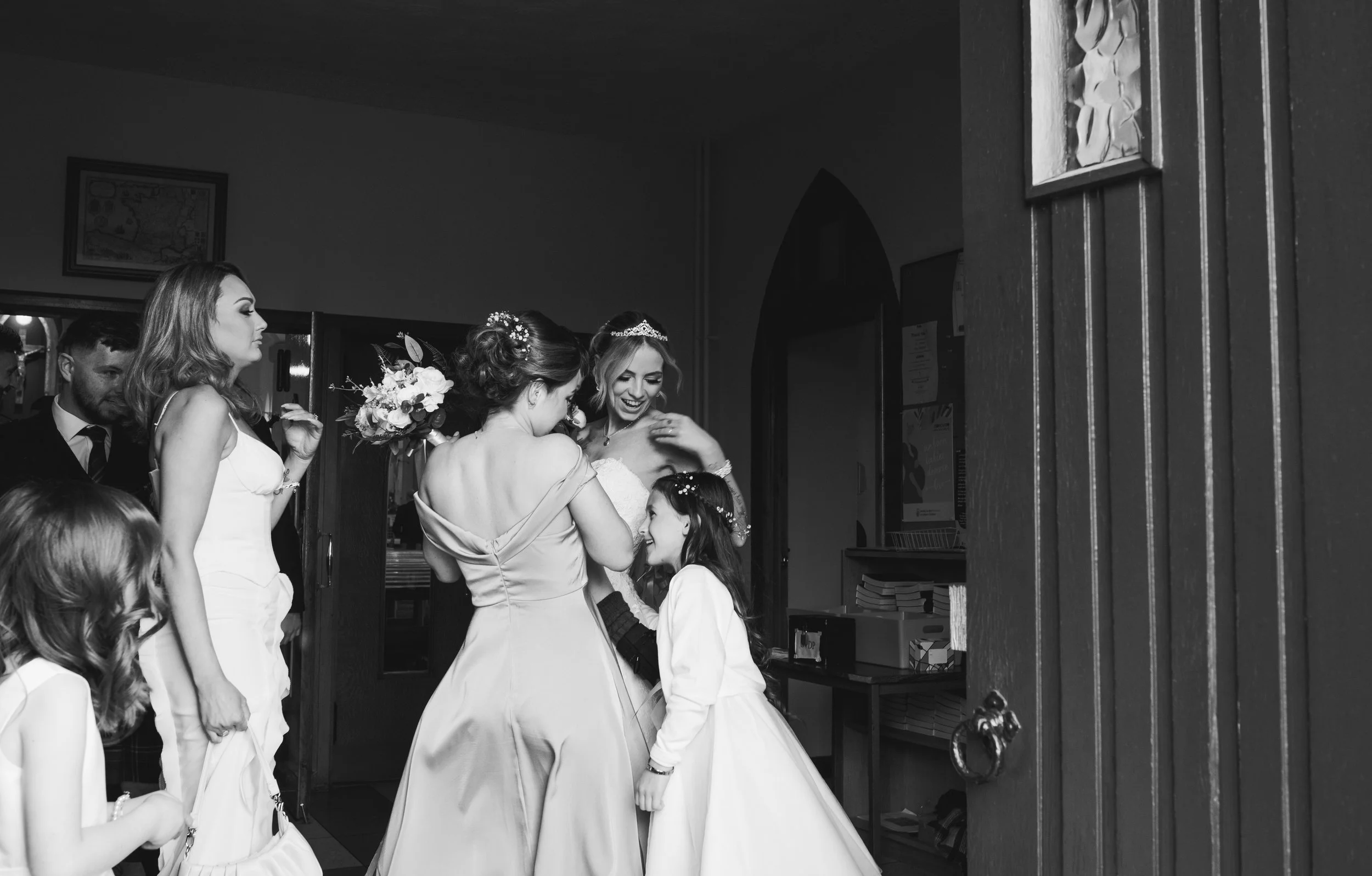 Bride laughing with her bridesmaids and flower girls after the wedding ceremony