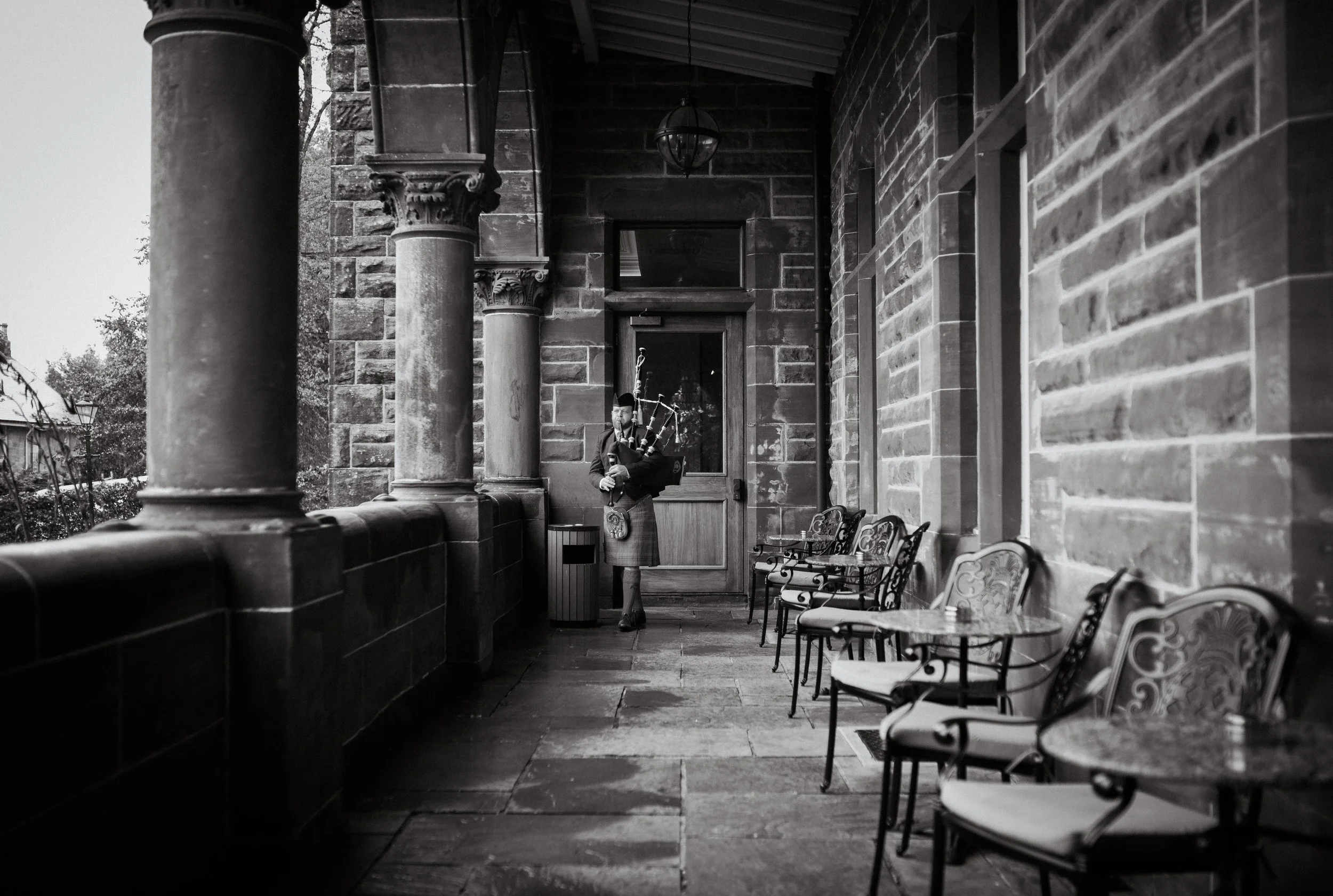 Black and white venue exterior with piper walking