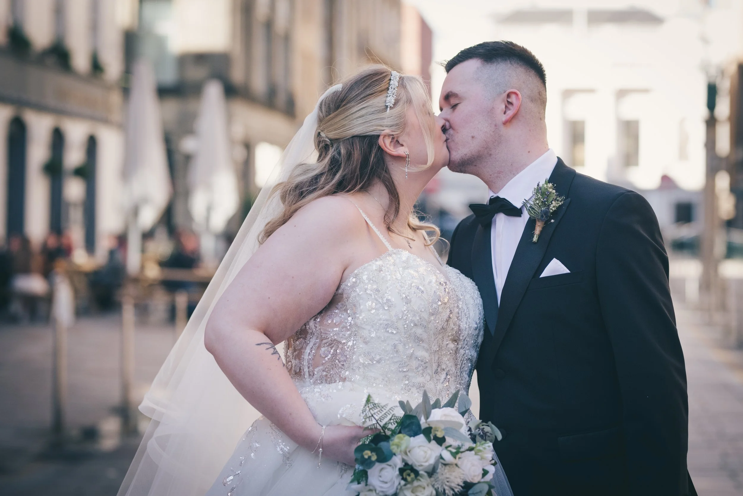 Newlywed couple sharing a kiss during their Glasgow city centre wedding portraits