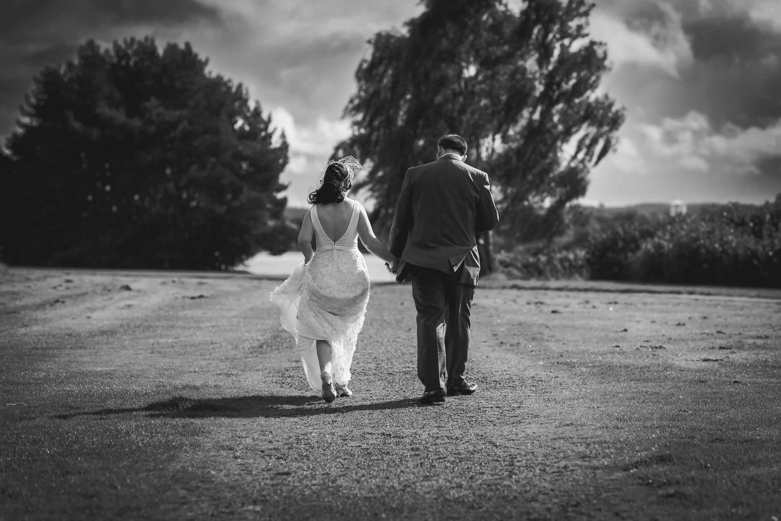 Newlywed couple walking together across the grounds after their wedding